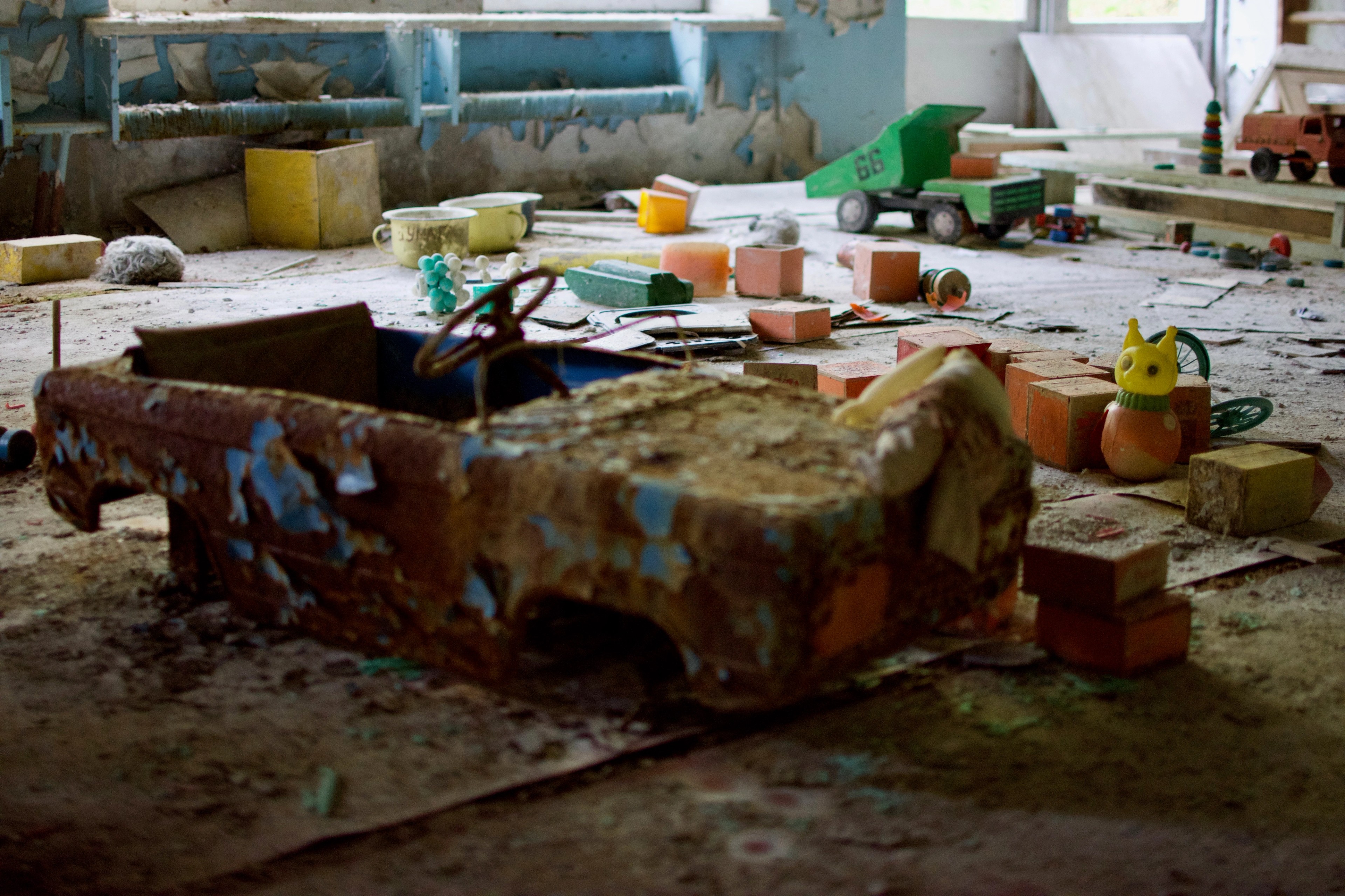 Tables and scattered items remain in a damaged classroom.