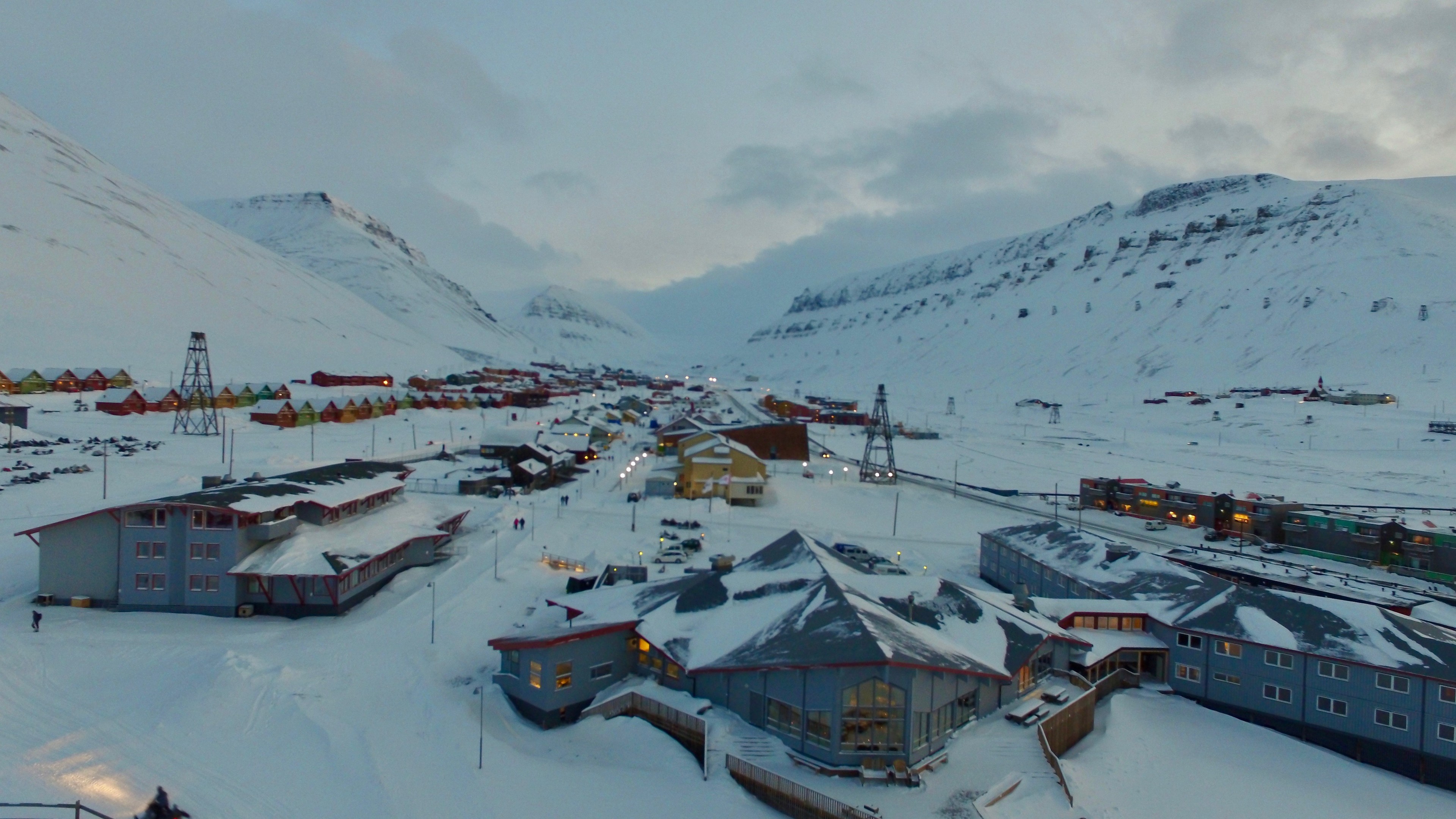 Aerial view of a snow-covered coastal settlement and harbor.