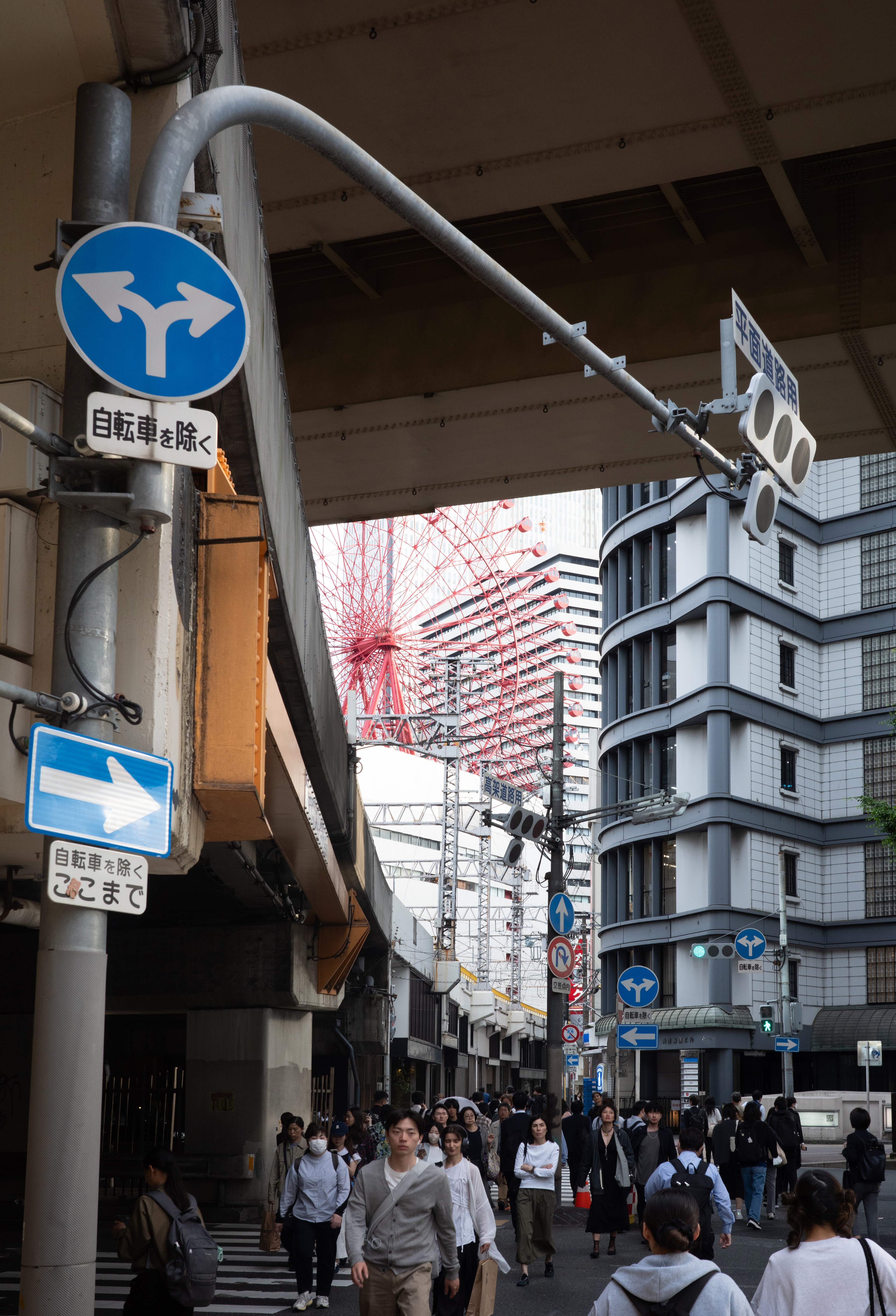 Bright shop signs cluster above a narrow city street.