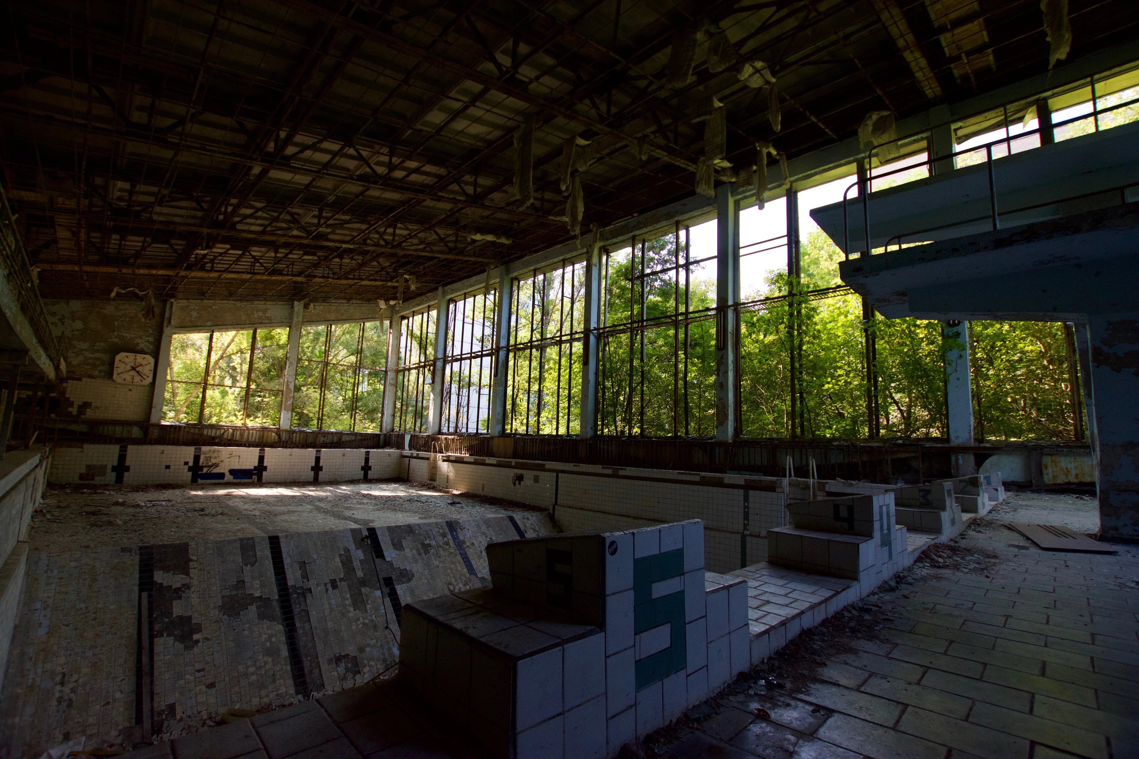 An open tiled room with damaged roof supports and windows.