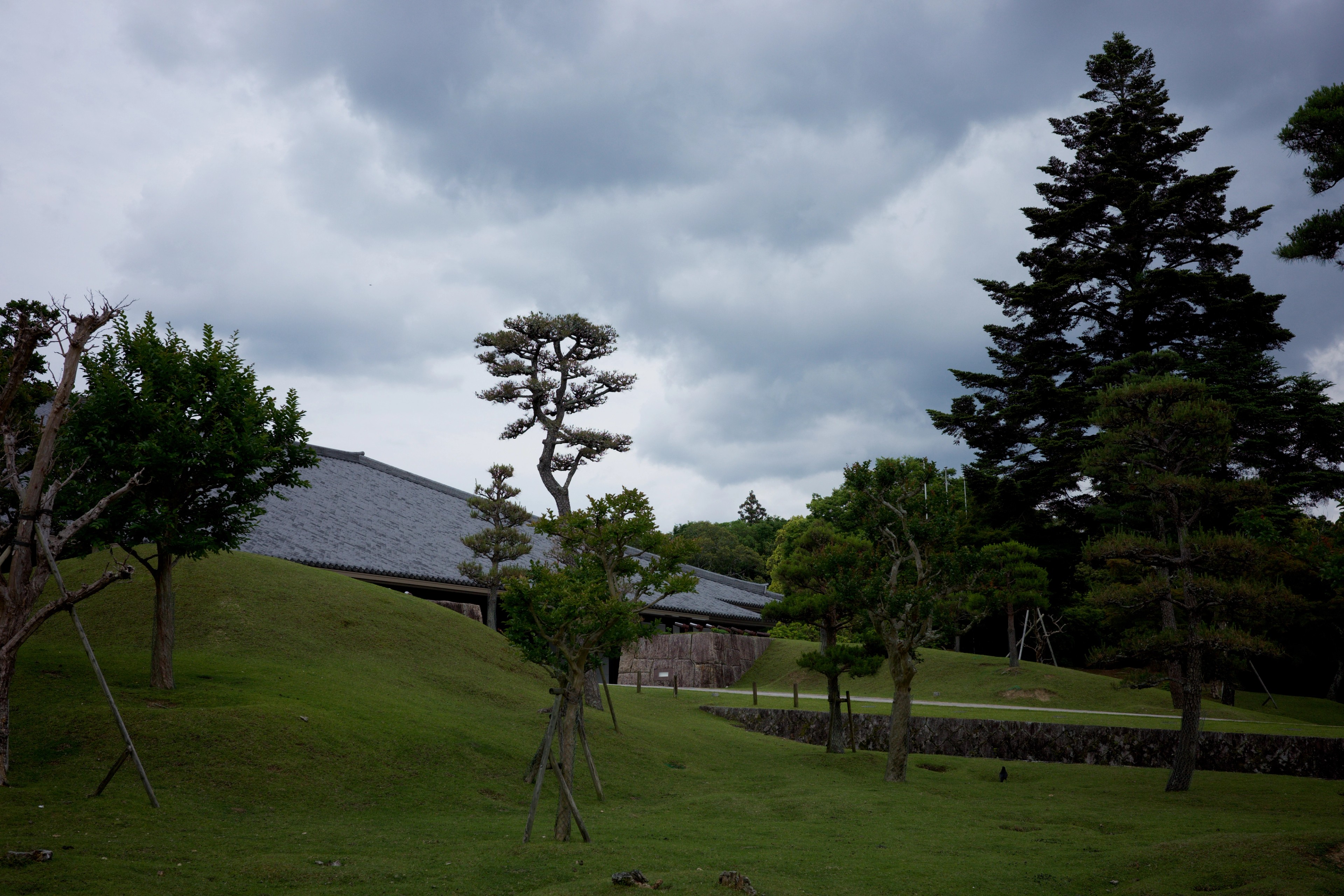 A green park lies beneath a cloudy sky.