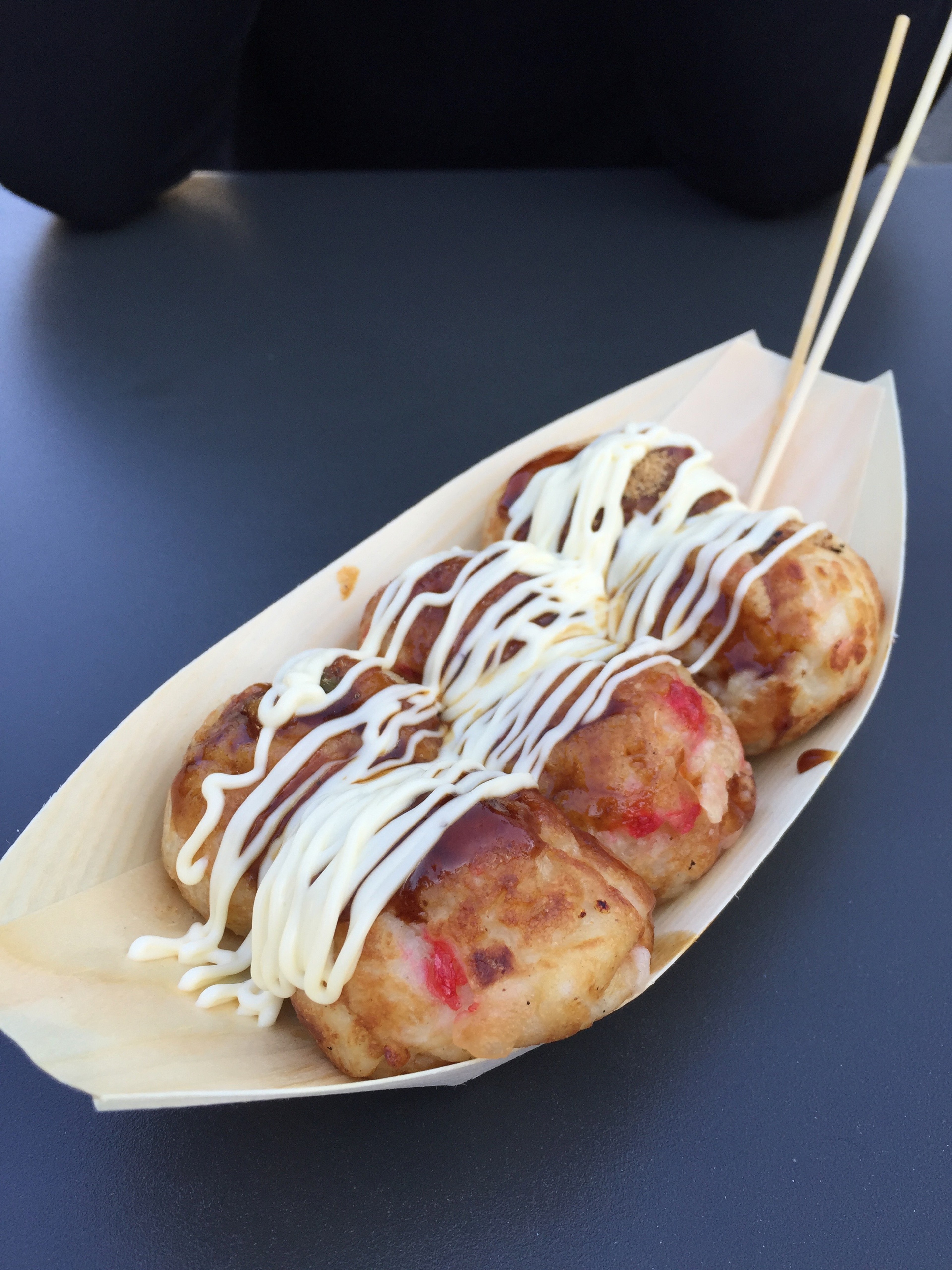 Several takoyaki balls are served with sauce and mayonnaise.