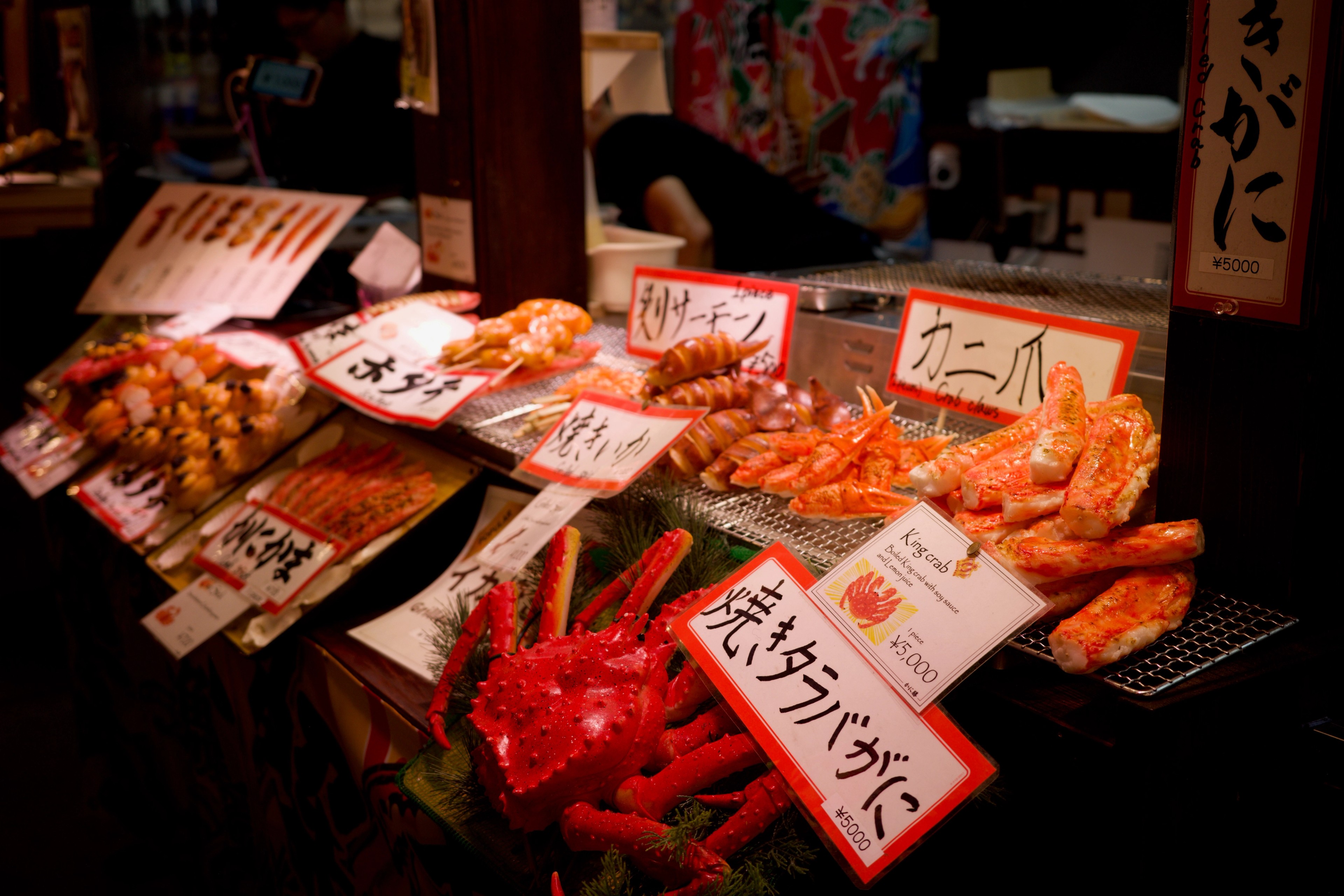 Seafood and prepared dishes fill a market stall.