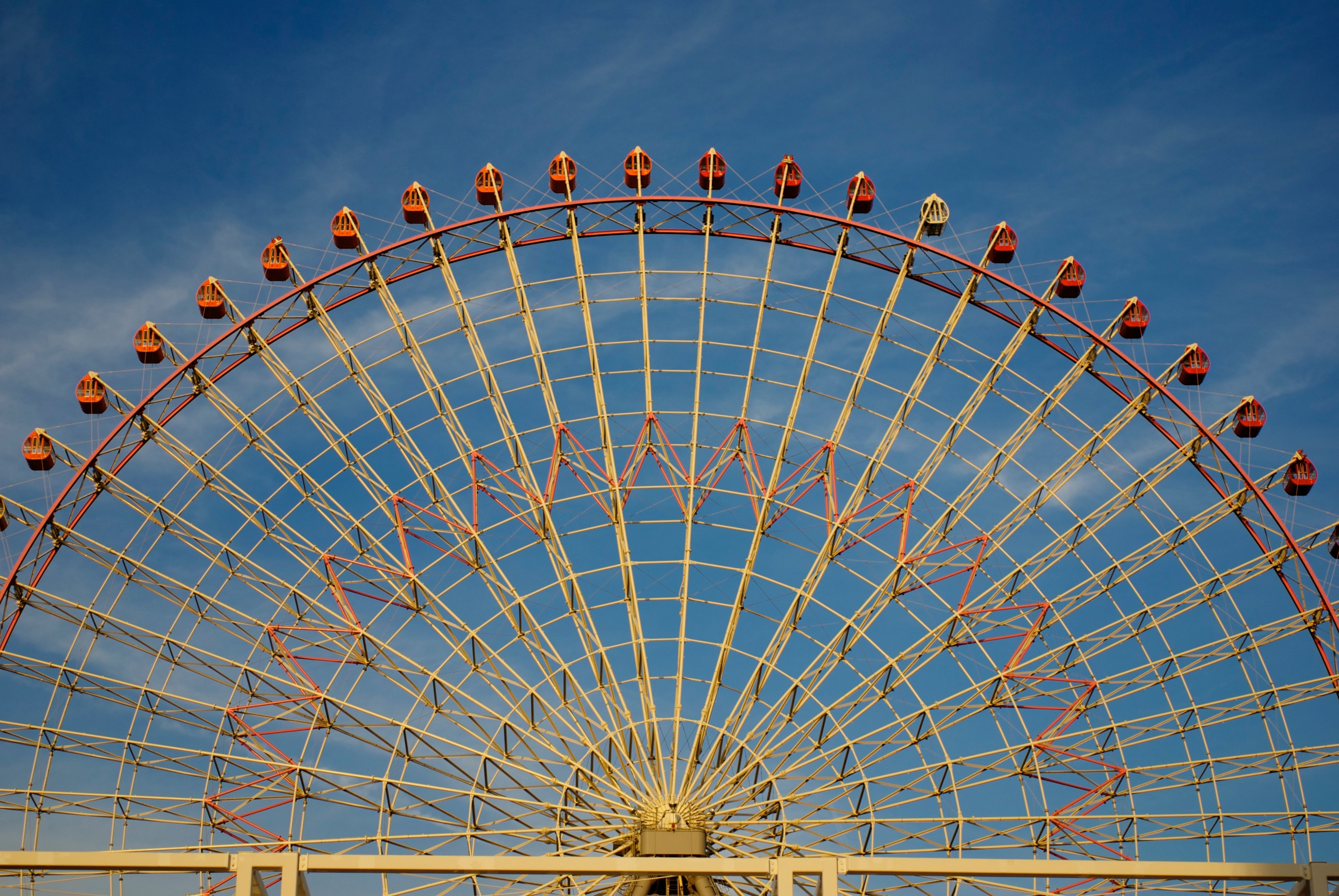 A large Ferris wheel rises against a clear blue sky.