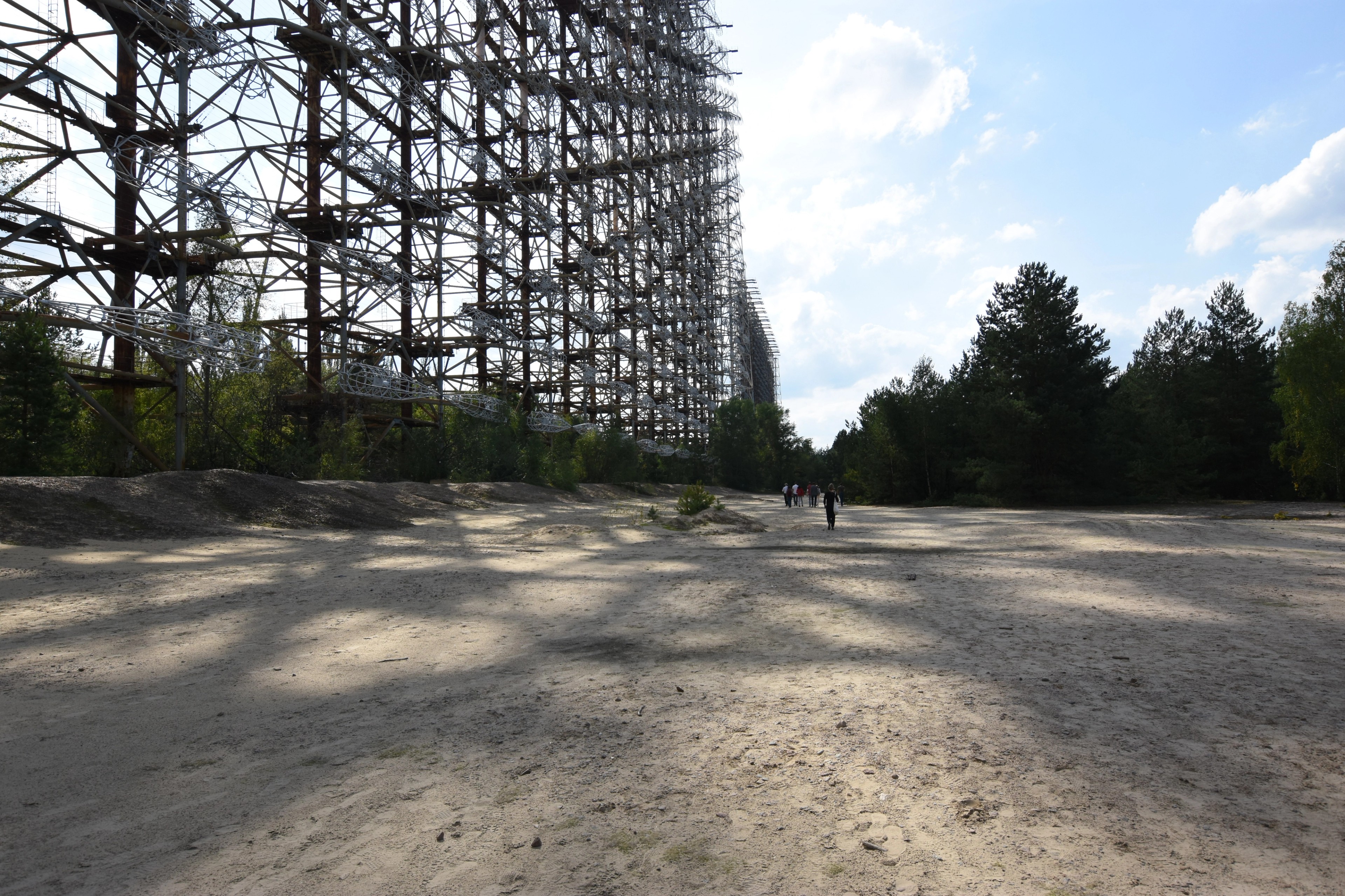 The Duga radar structure stands beside an open sandy clearing.