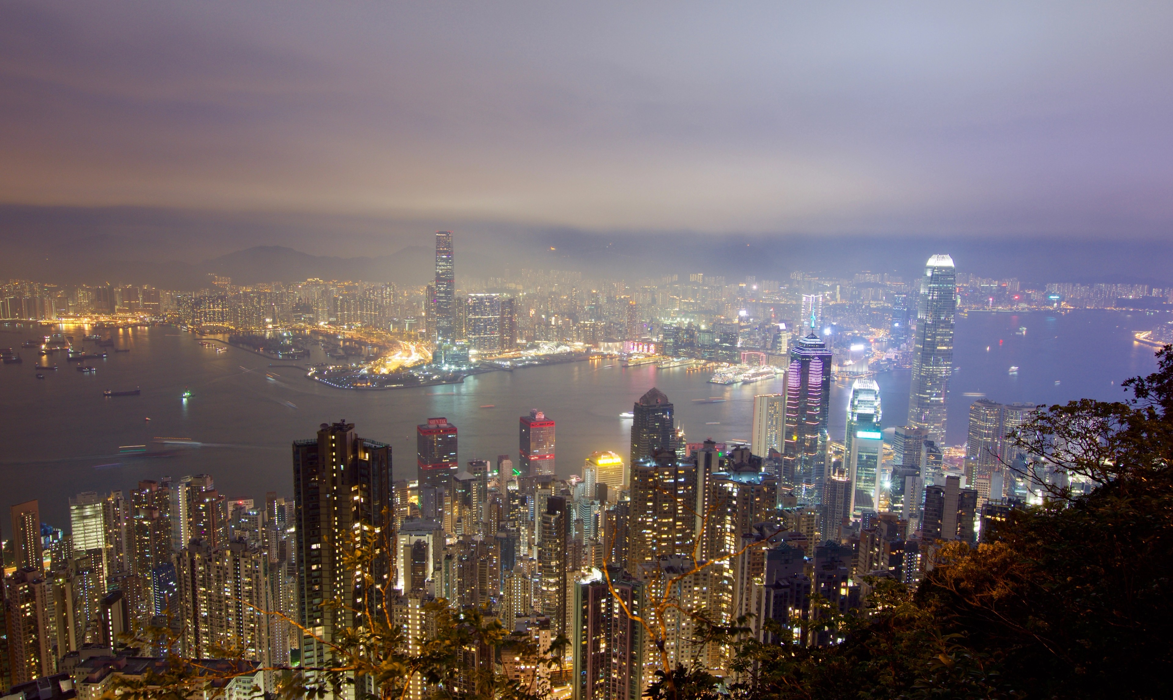 Hong Kong skyline and harbour at night in hazy light.