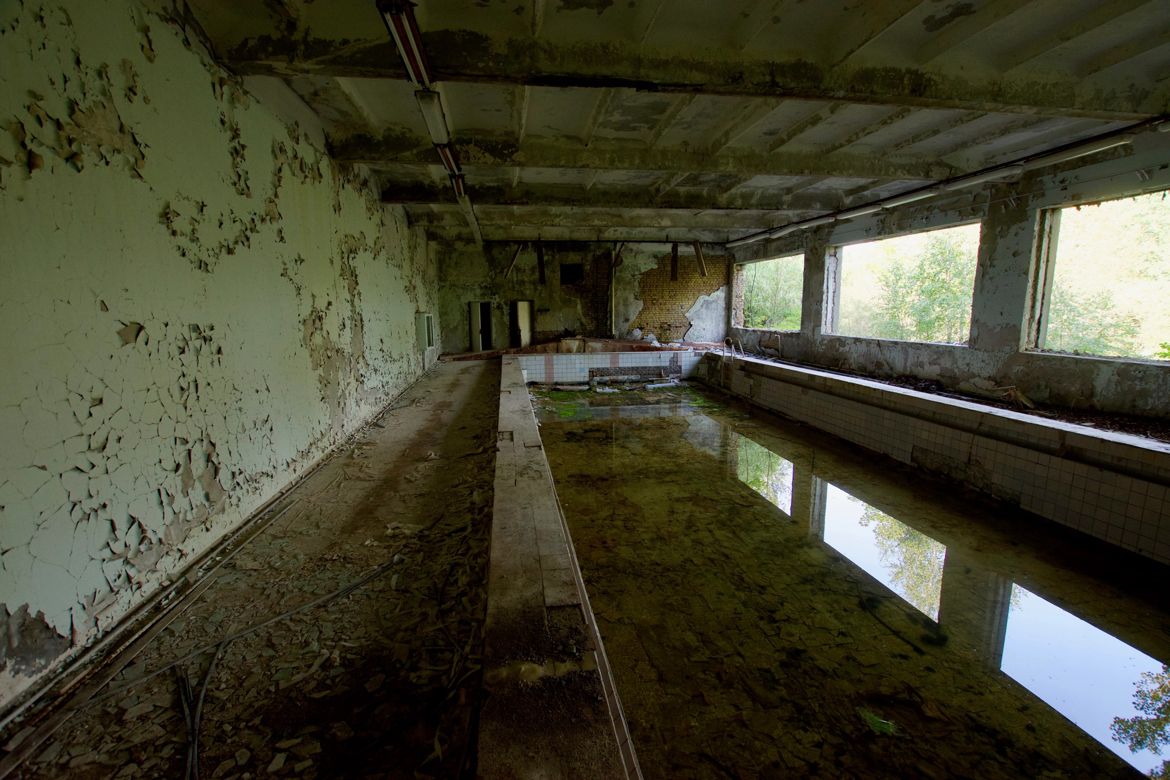 An empty flooded corridor reflects the windows and ceiling.