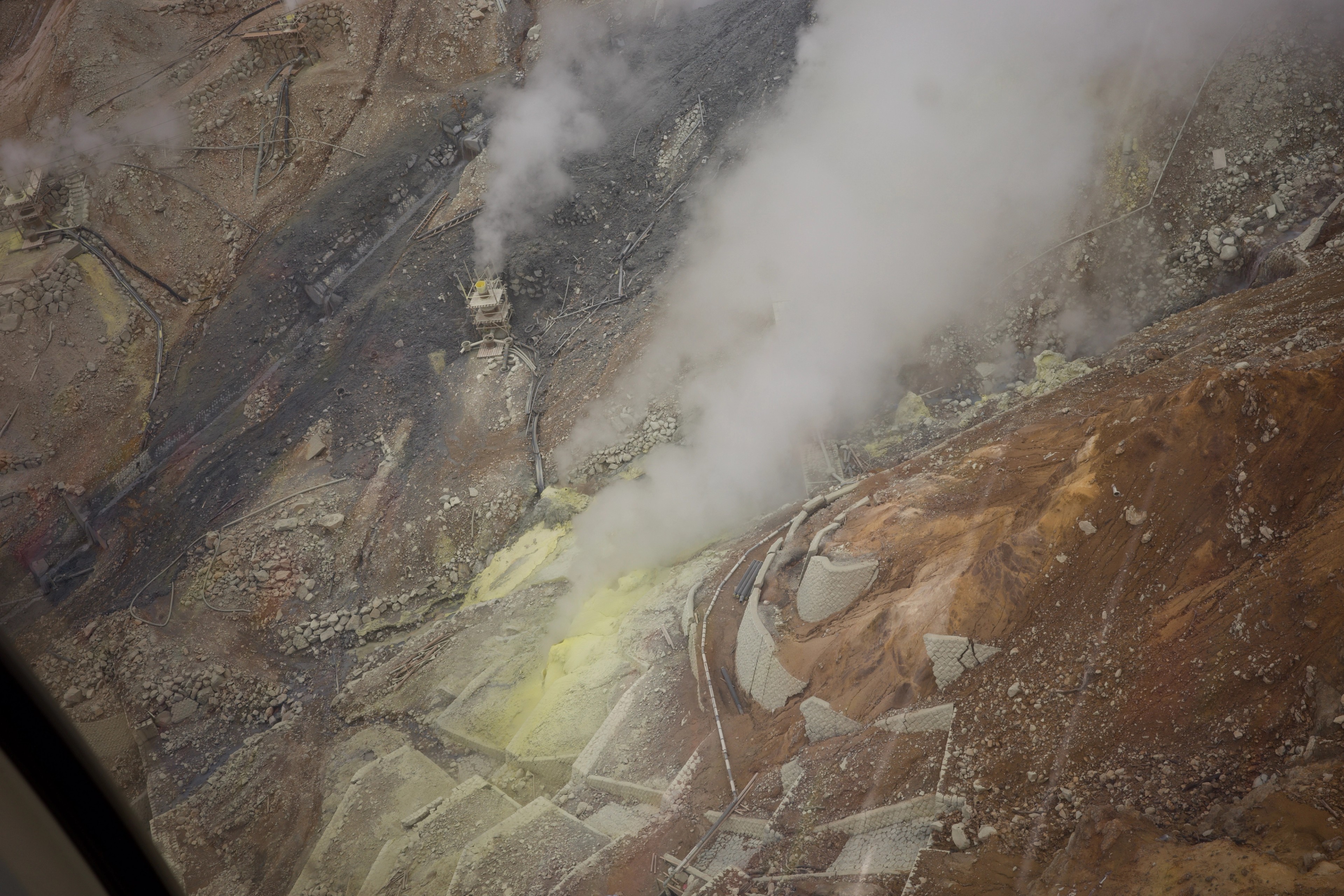 White steam rises from mineral-stained rocks.