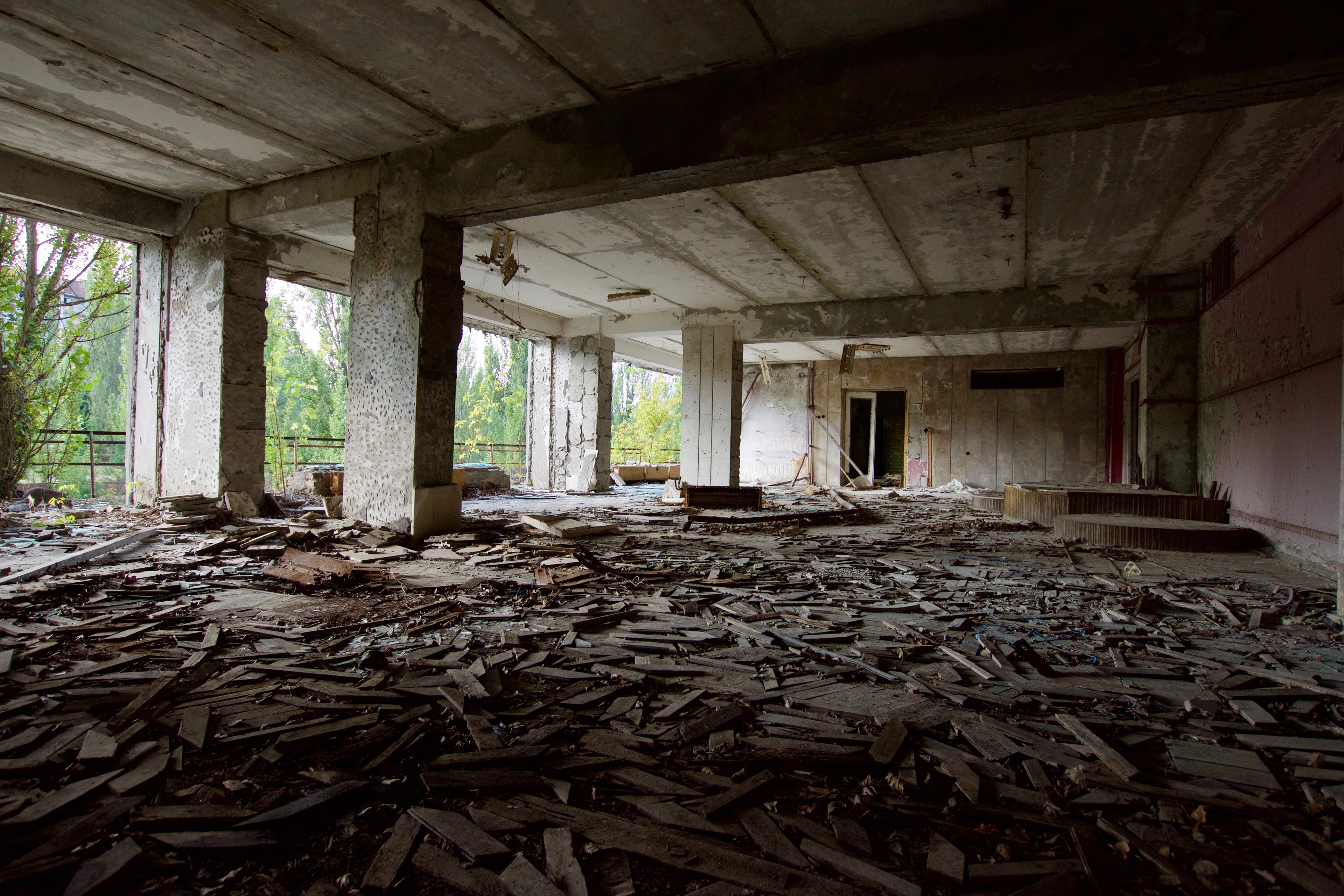 A derelict industrial room with a collapsed roof and rubble.