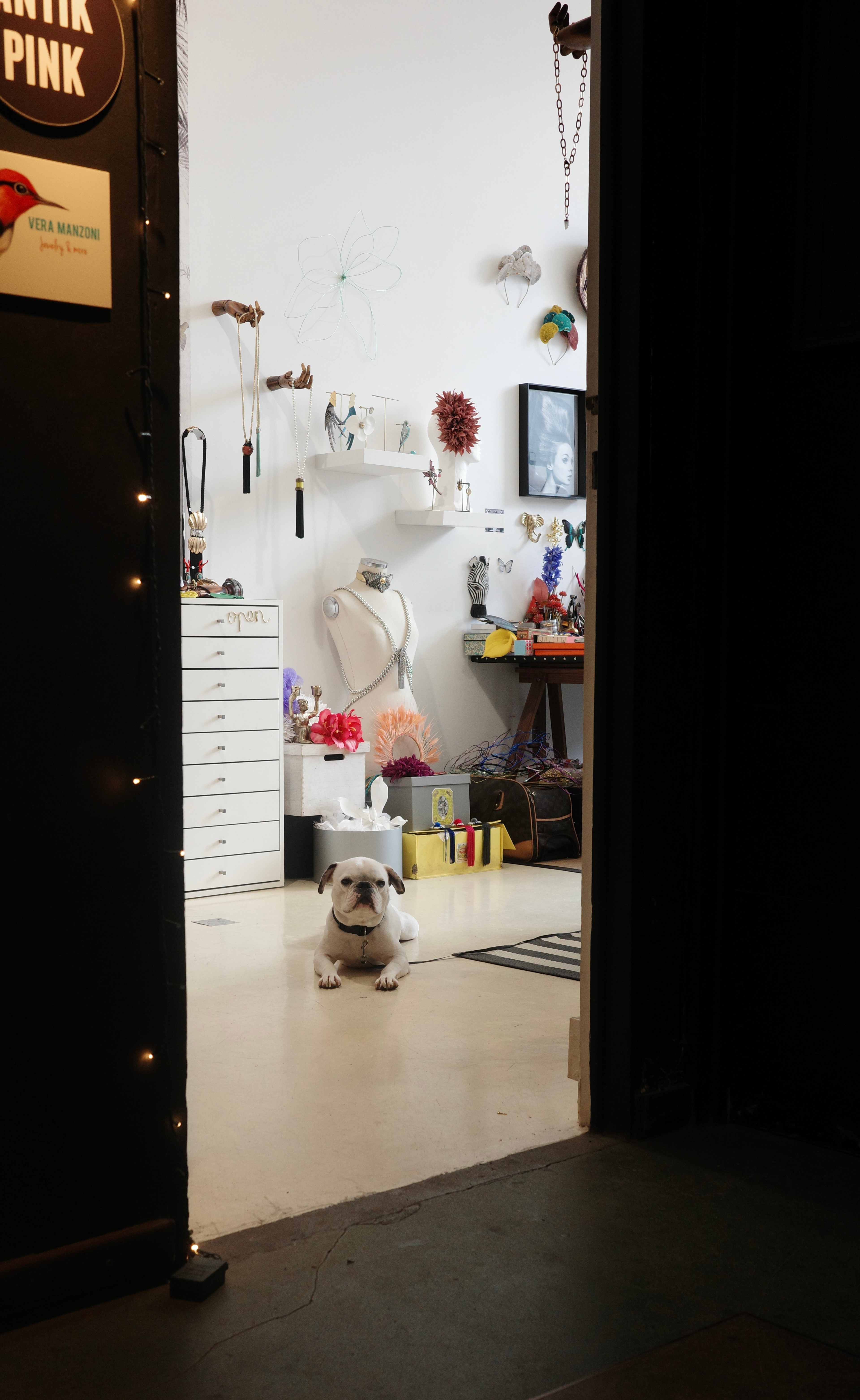 A bright shop interior is visible through an open doorway from a dark corridor.