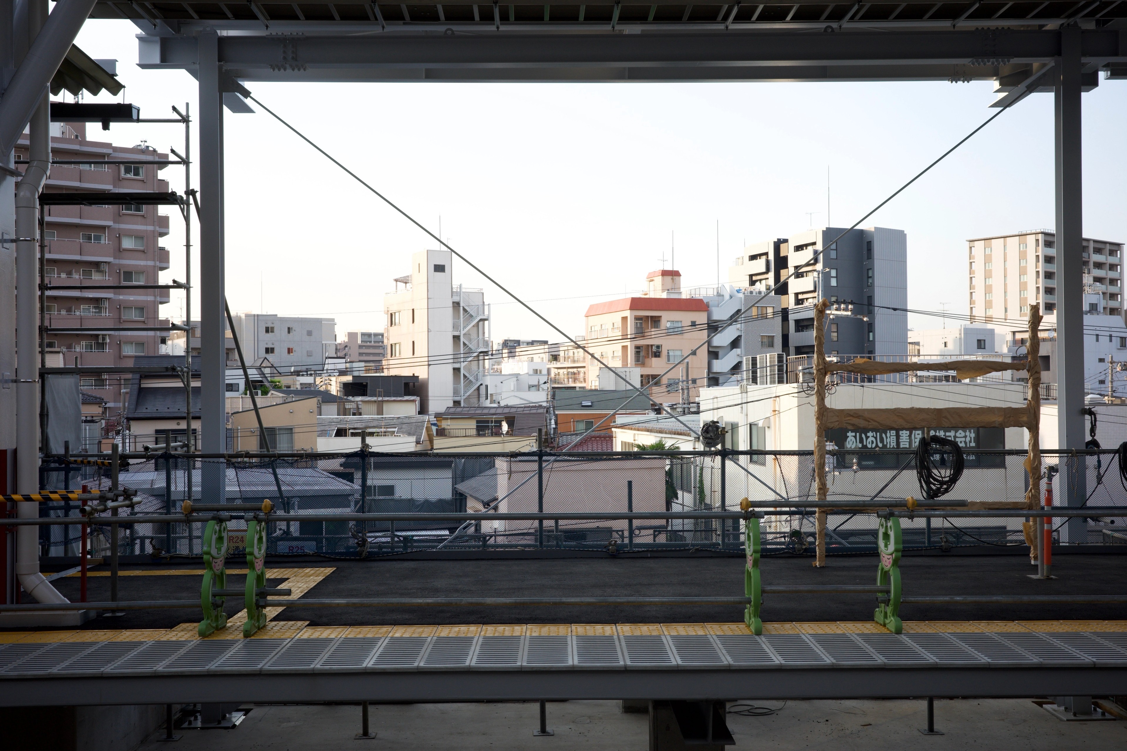 Railway tracks and low-rise neighborhoods viewed from a station.