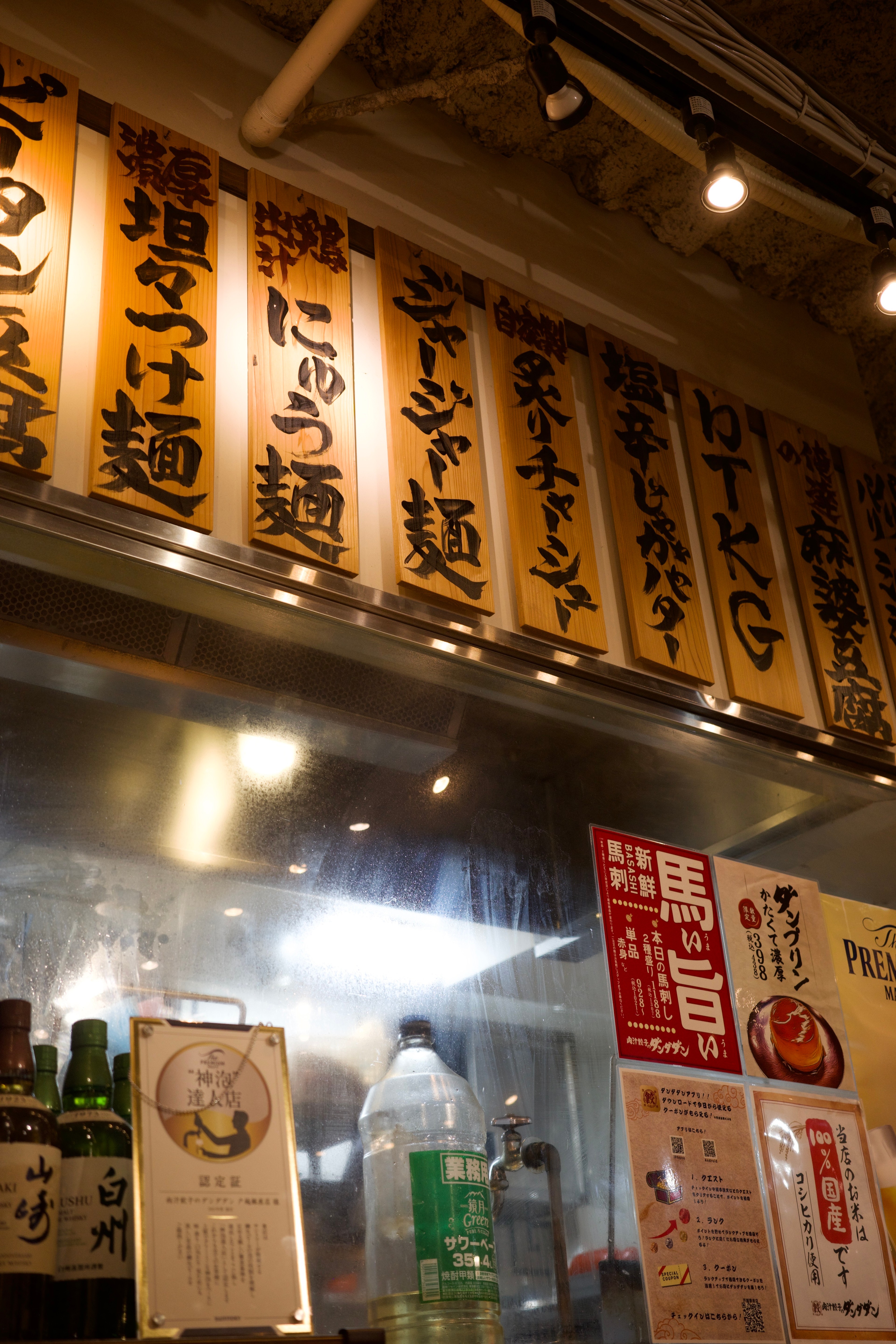 Lanterns and signs hang above a small restaurant entrance.