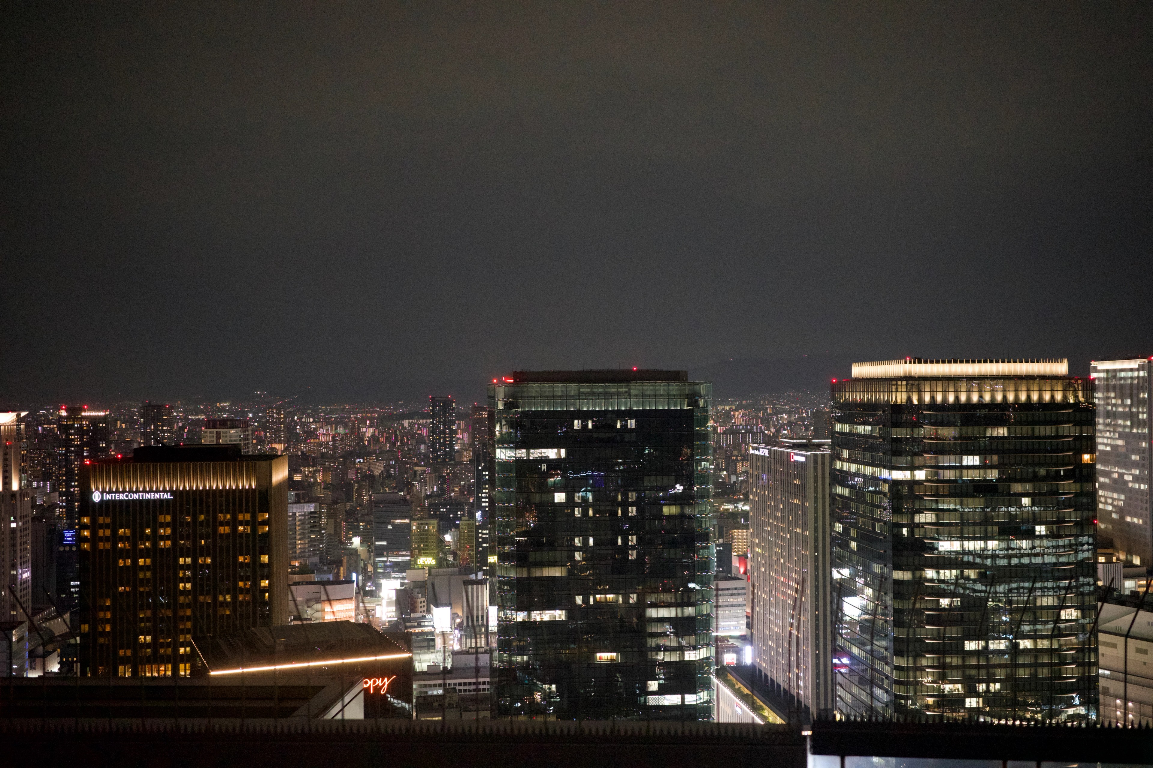 A row of illuminated offices seen from an upper floor.