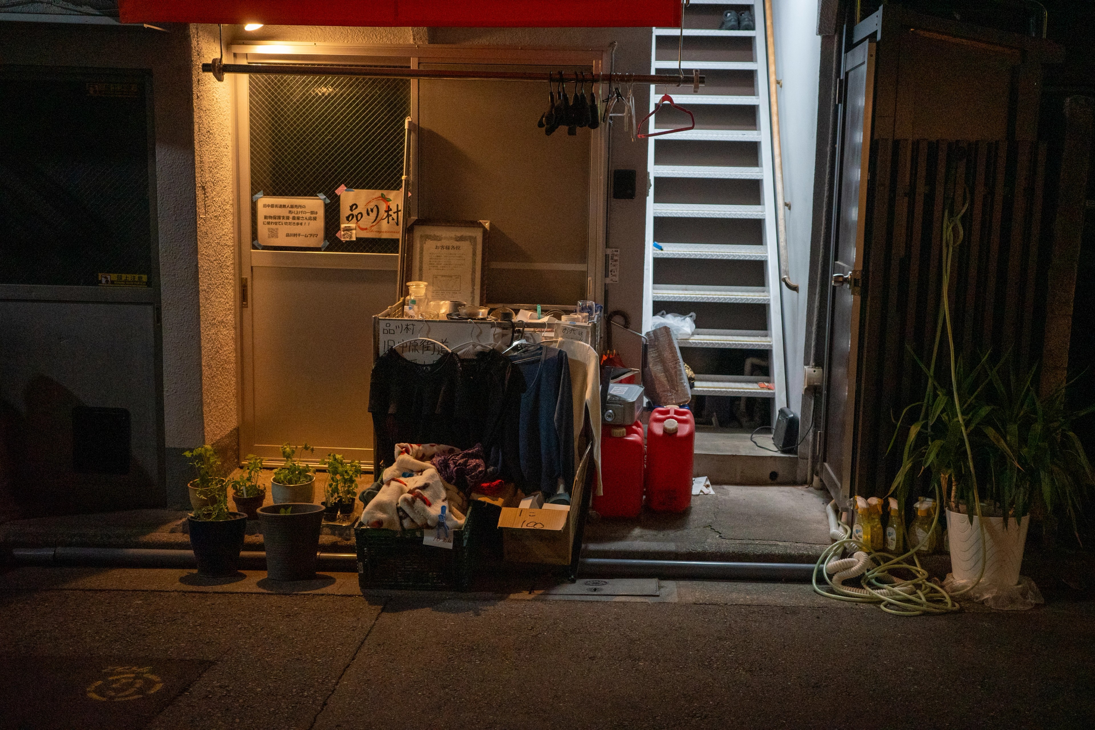 An open-front shop displays household goods on the sidewalk.