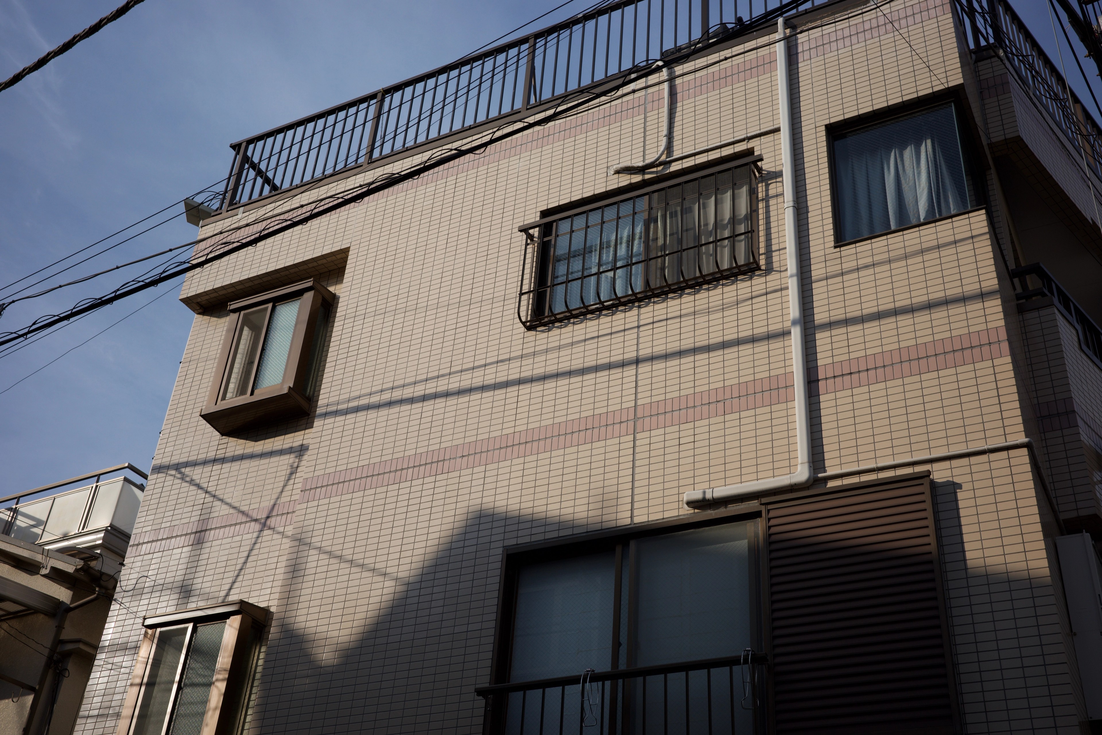 A narrow apartment building viewed from below.