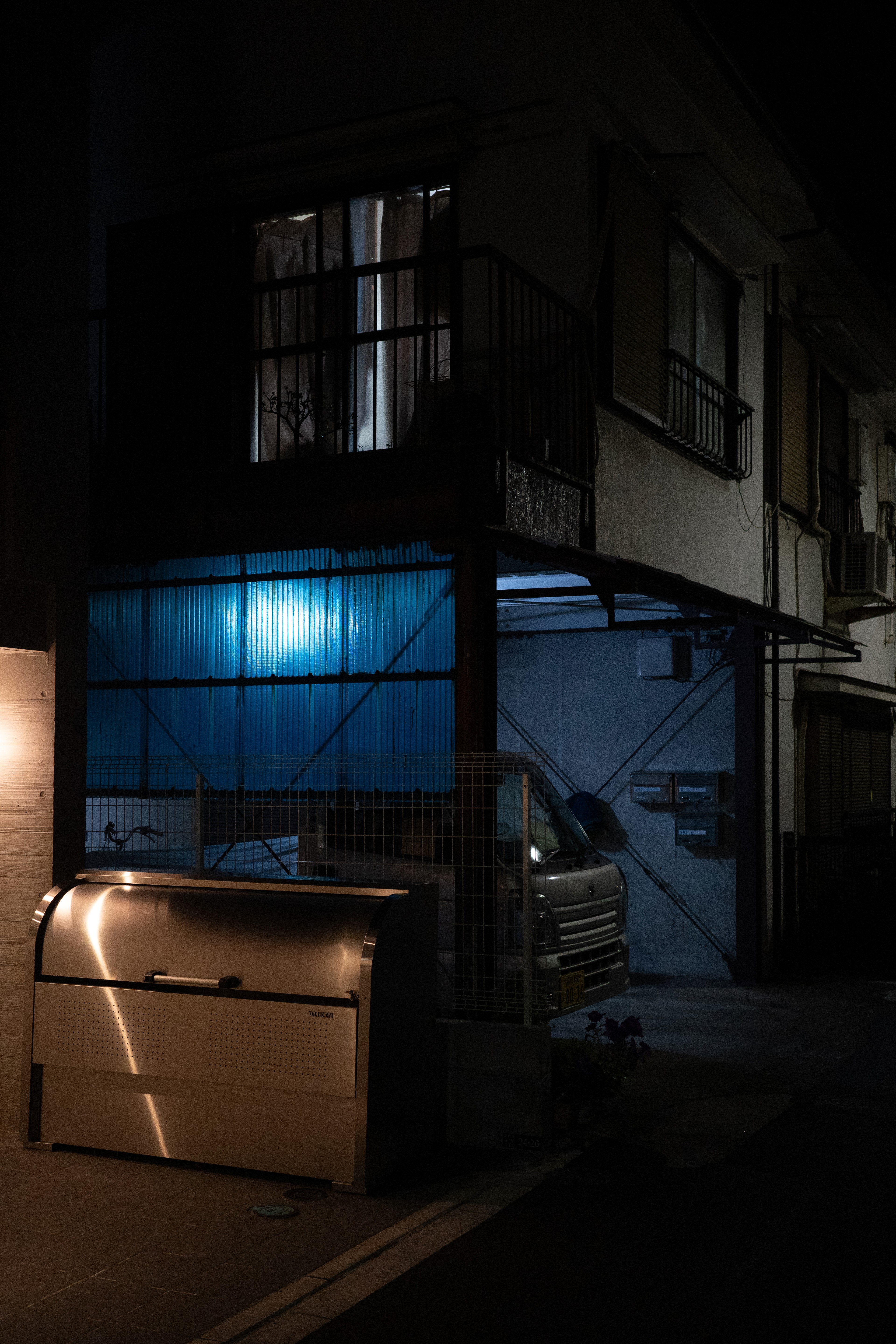 A small blue-lit storefront on a dark residential street.