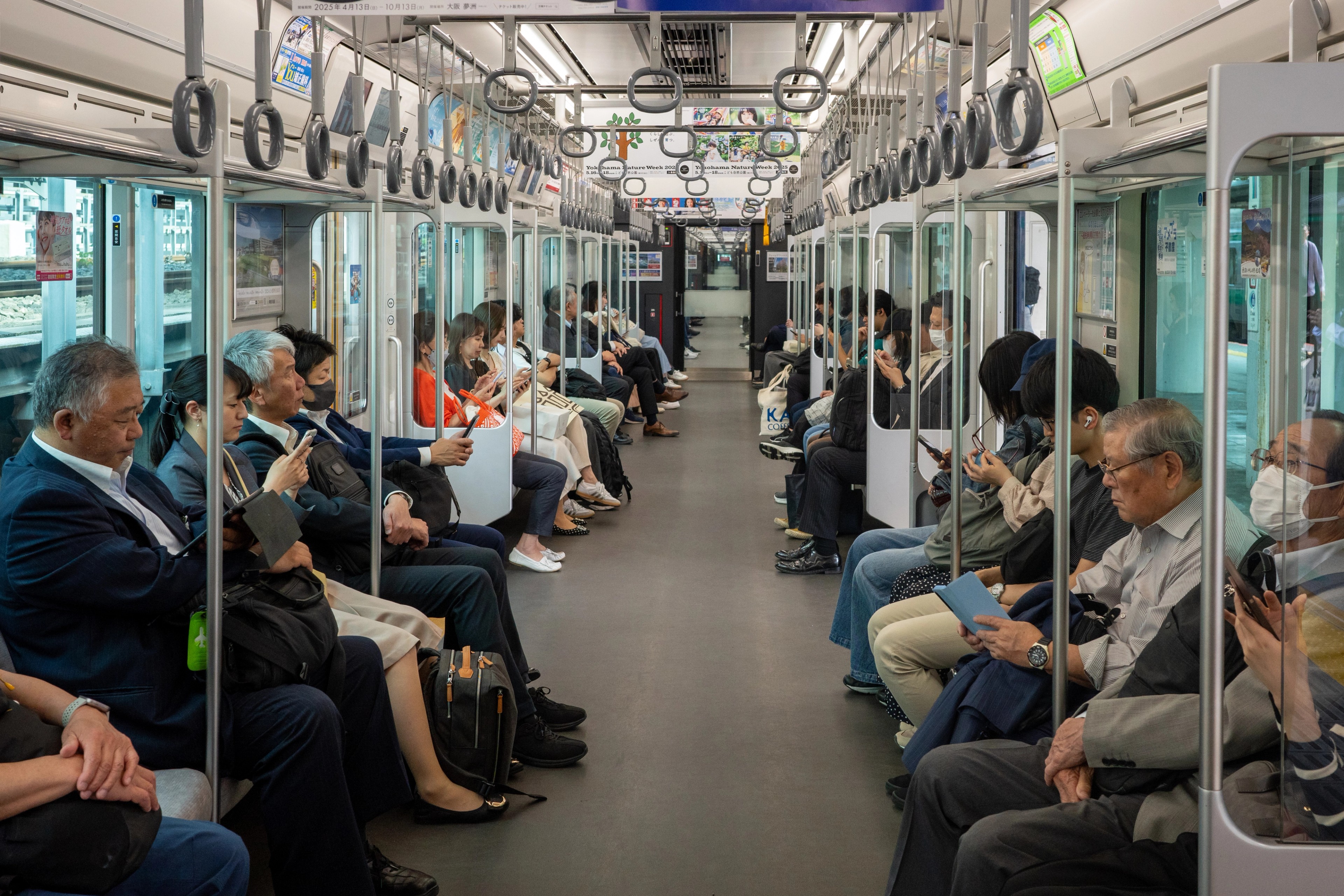Passengers sit inside a commuter train.