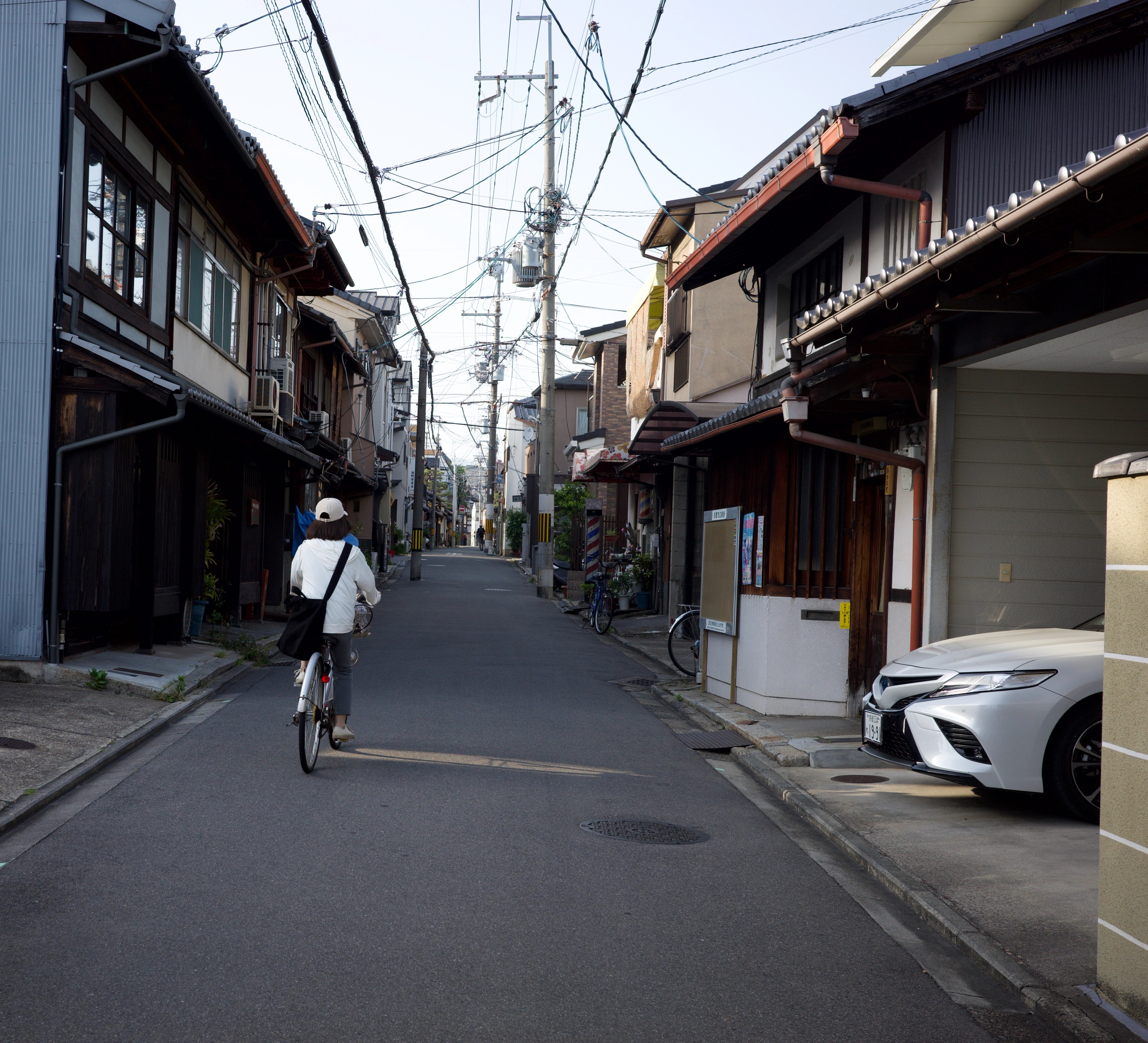 A person walks down a narrow residential street.