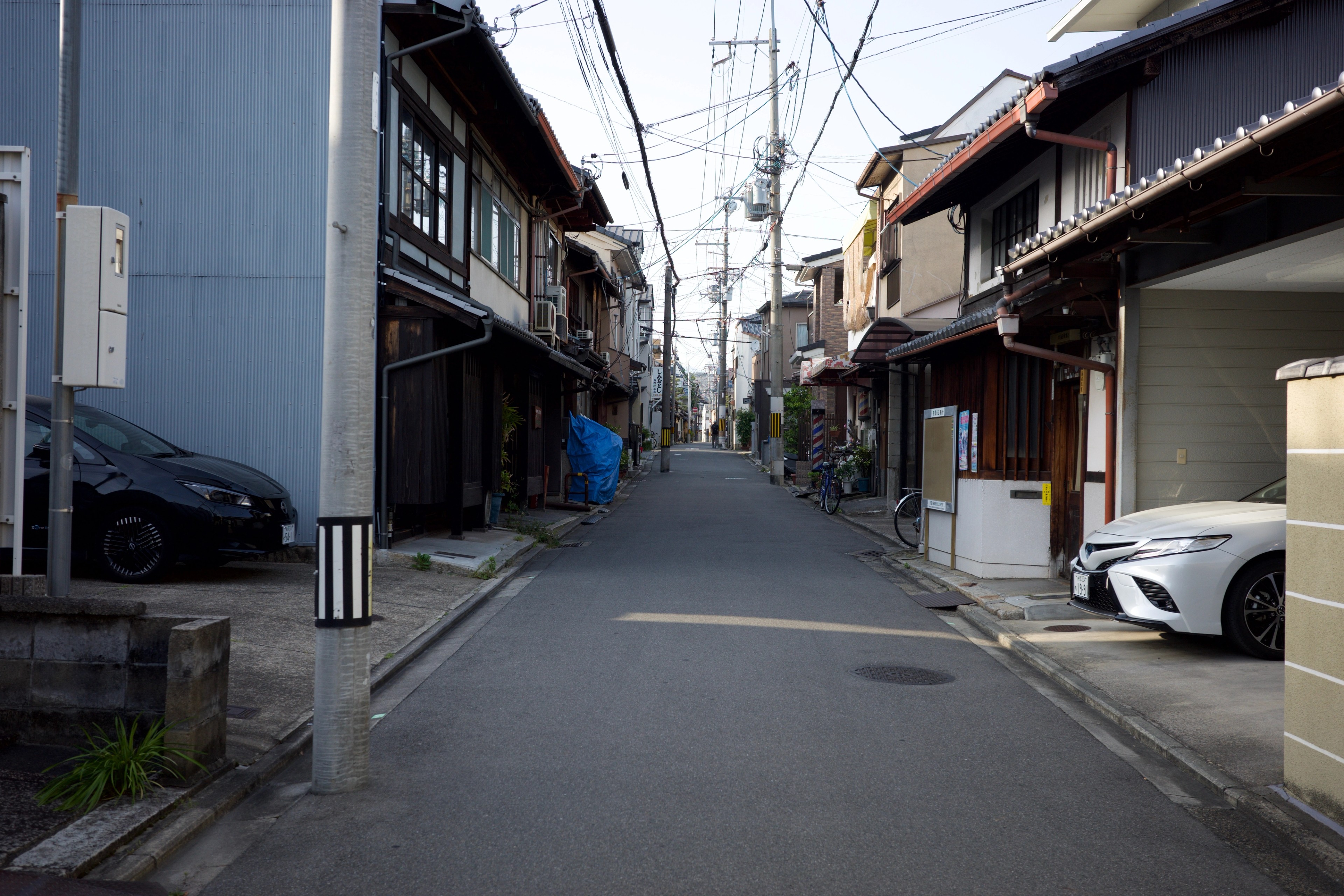A quiet street lined with traditional houses and a parked car.