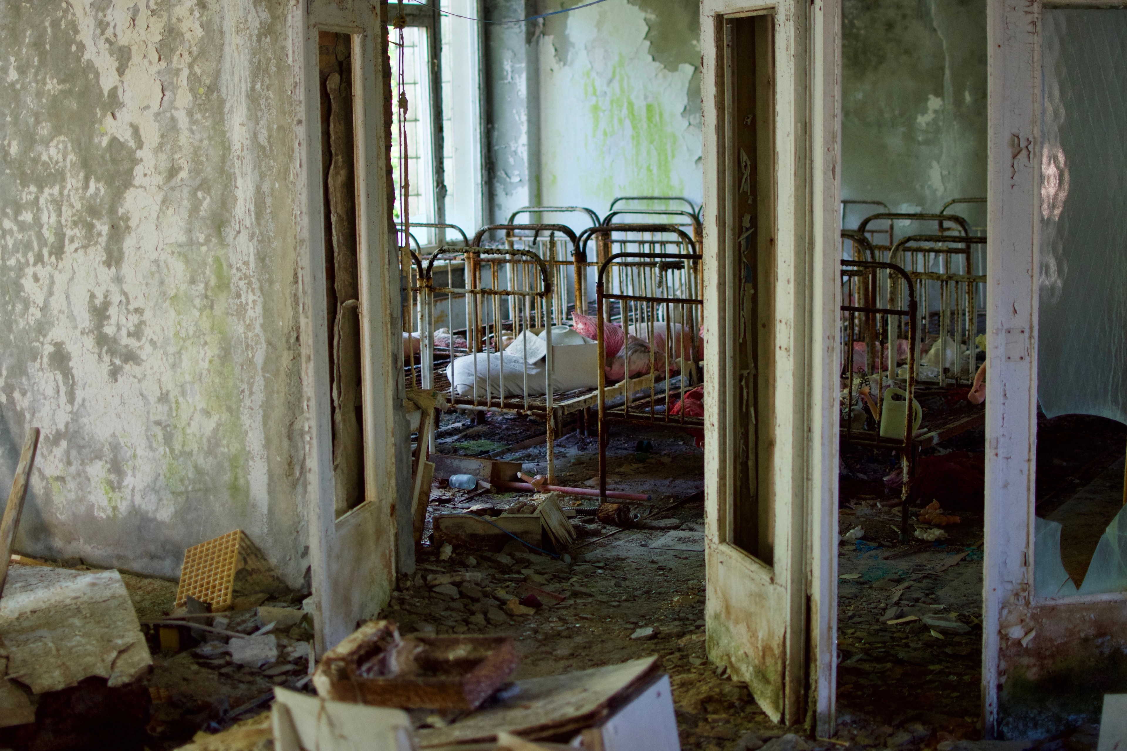 Metal bed frames are visible through a series of doorways.