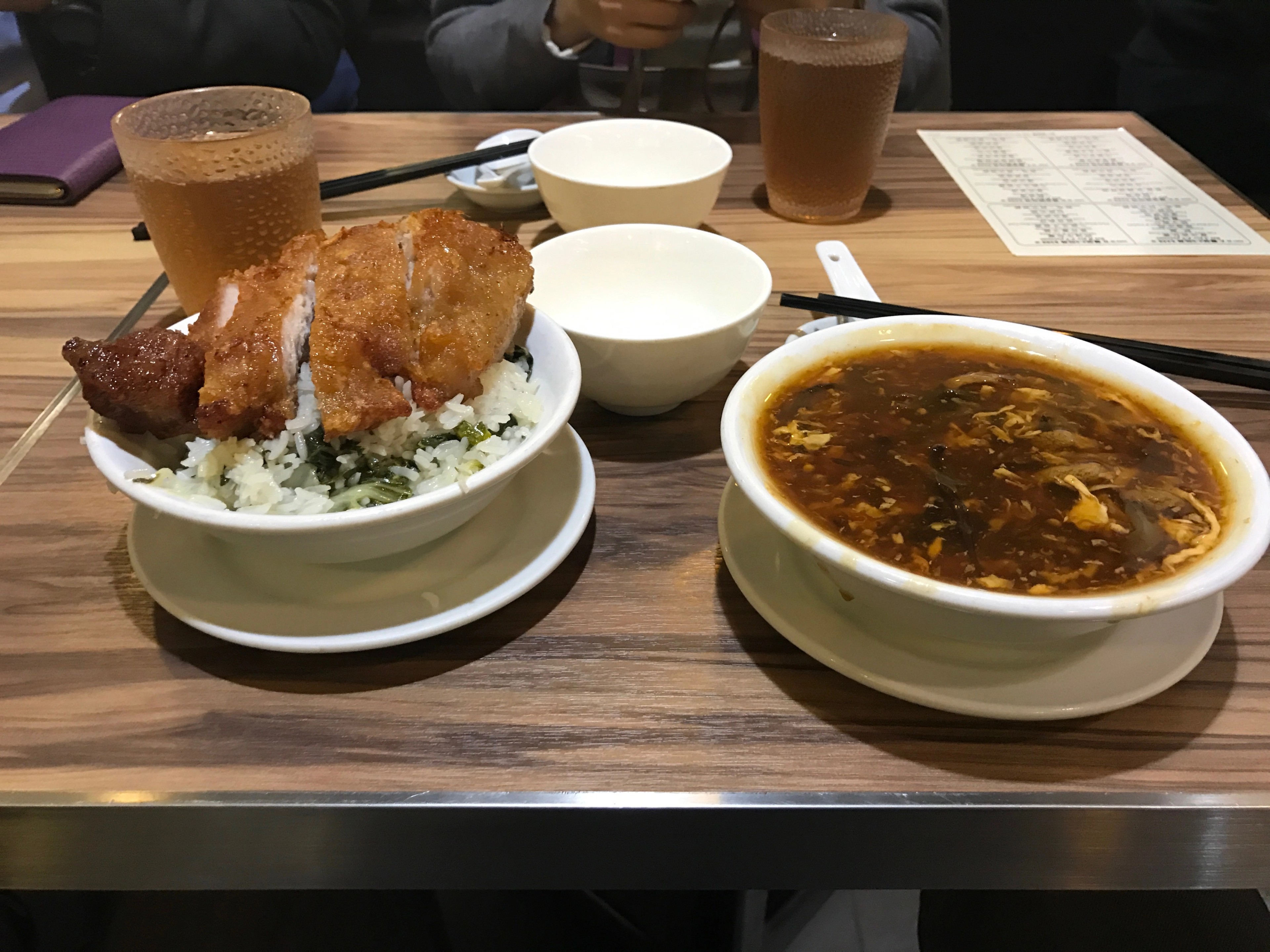 A fried chicken leg, rice, and soup are served on a tray.