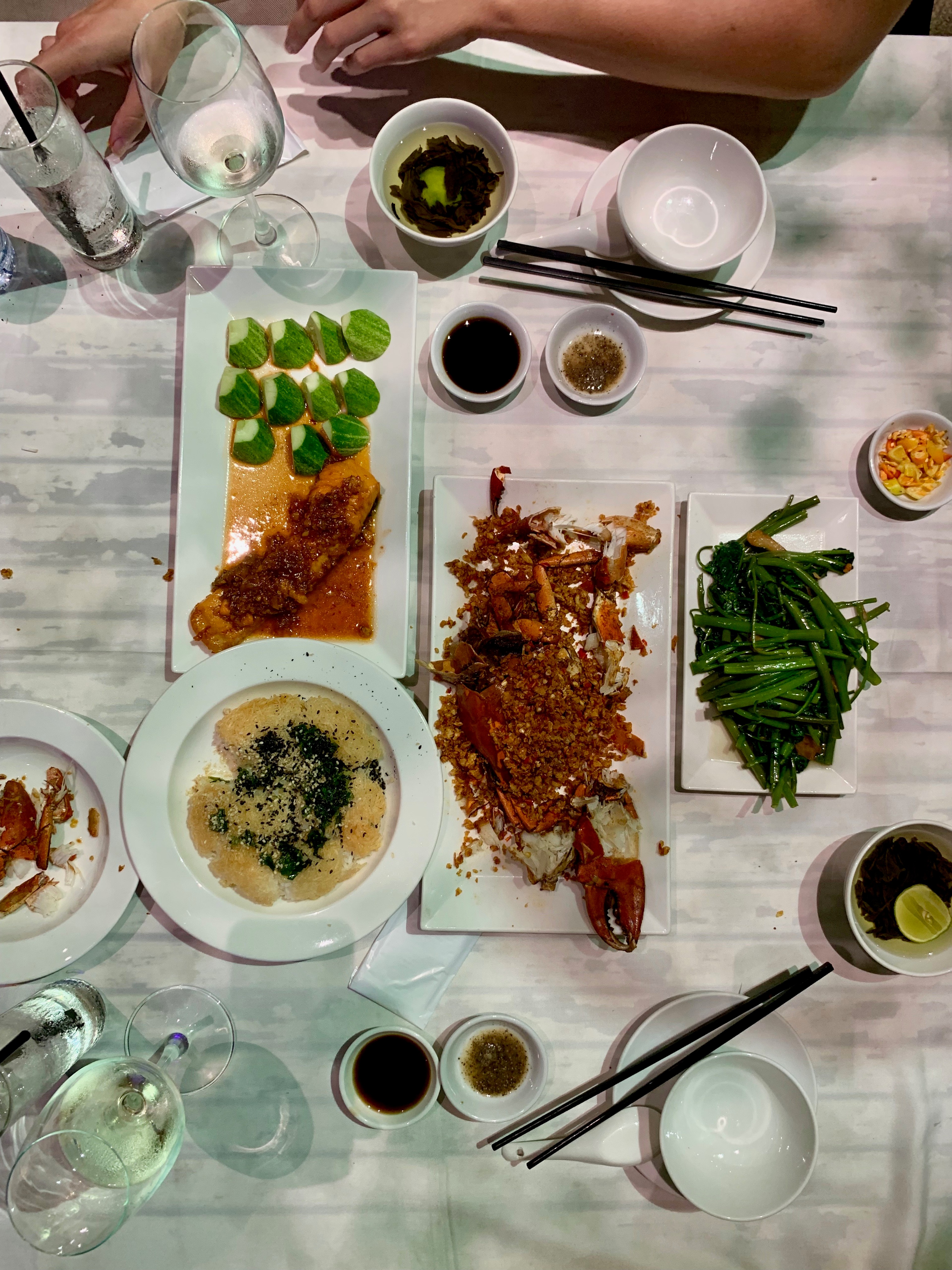 A Vietnamese meal with bowls of rice, greens, meat, and sauces is spread across a table.