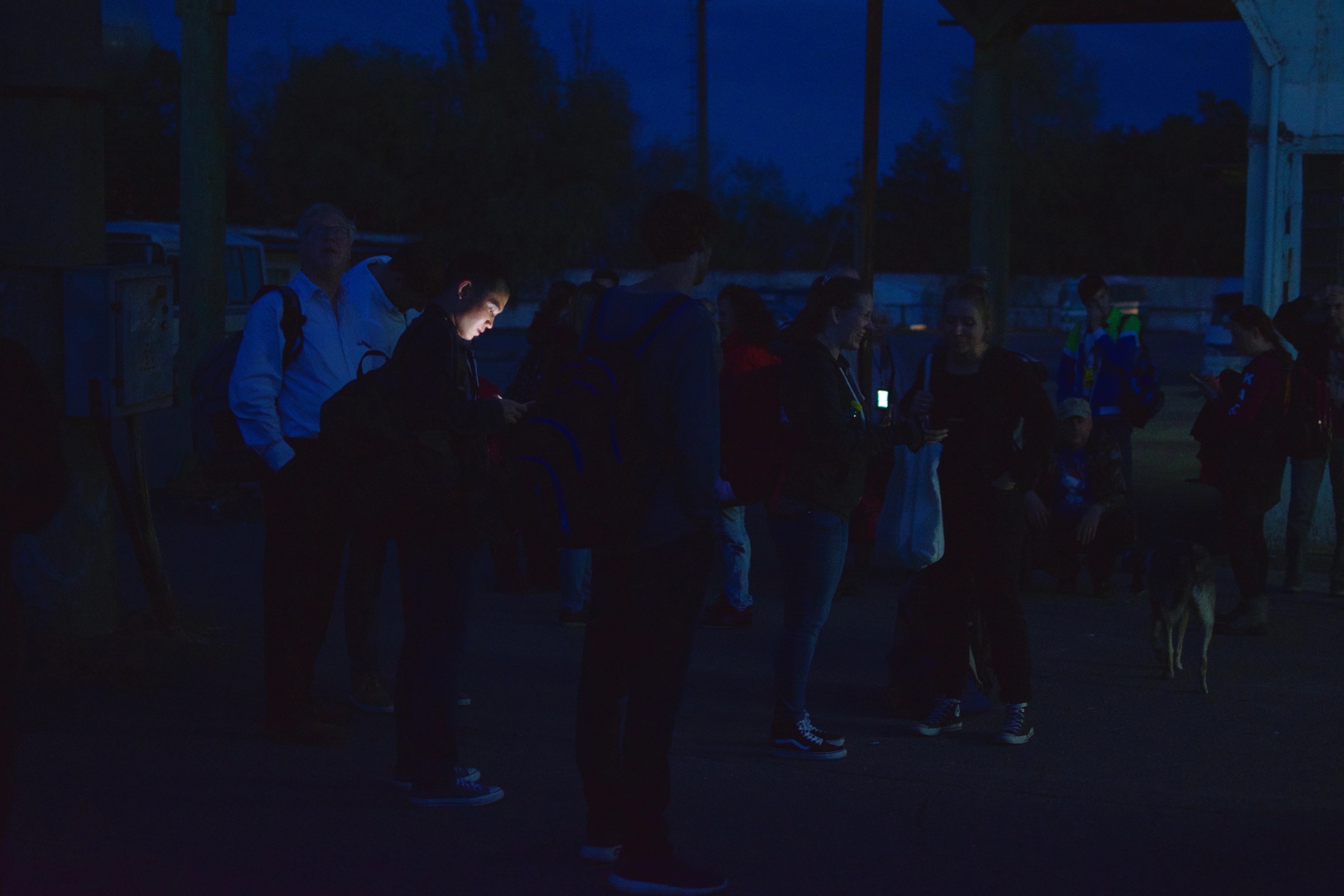 People gather inside a dark room at night.