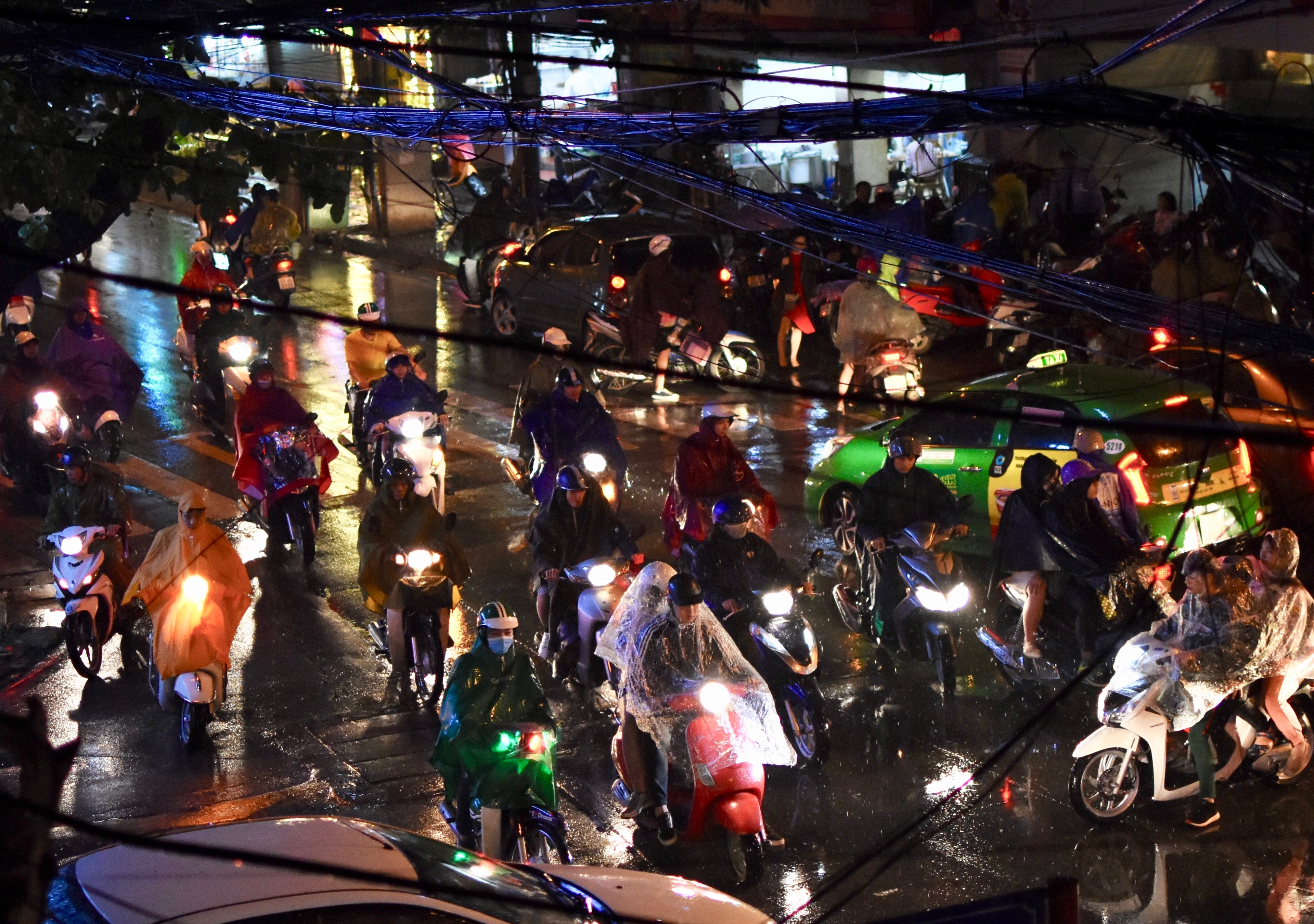 A crowded night market street glows with colorful lights.