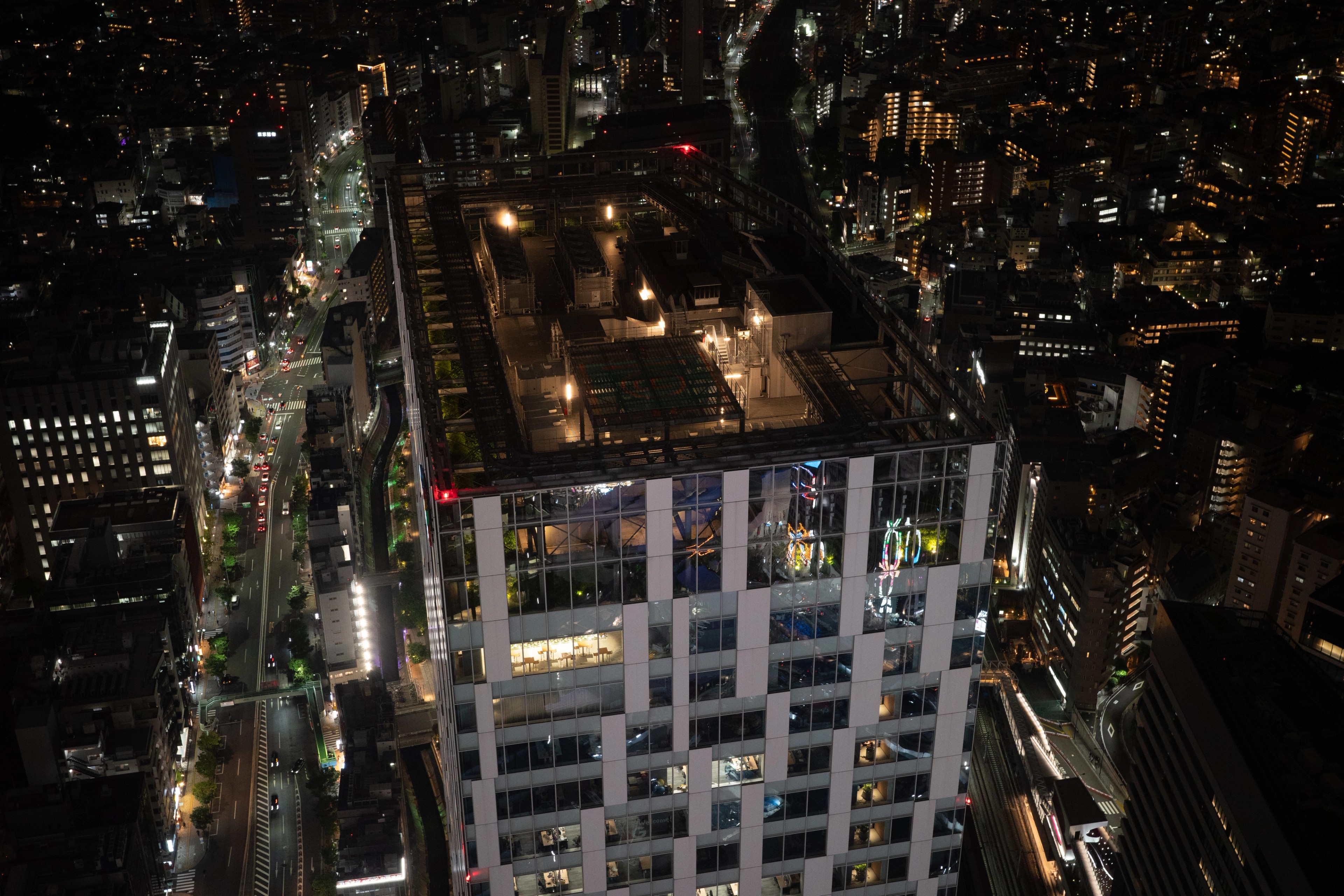 High-rise buildings and lit streets seen from above at night.