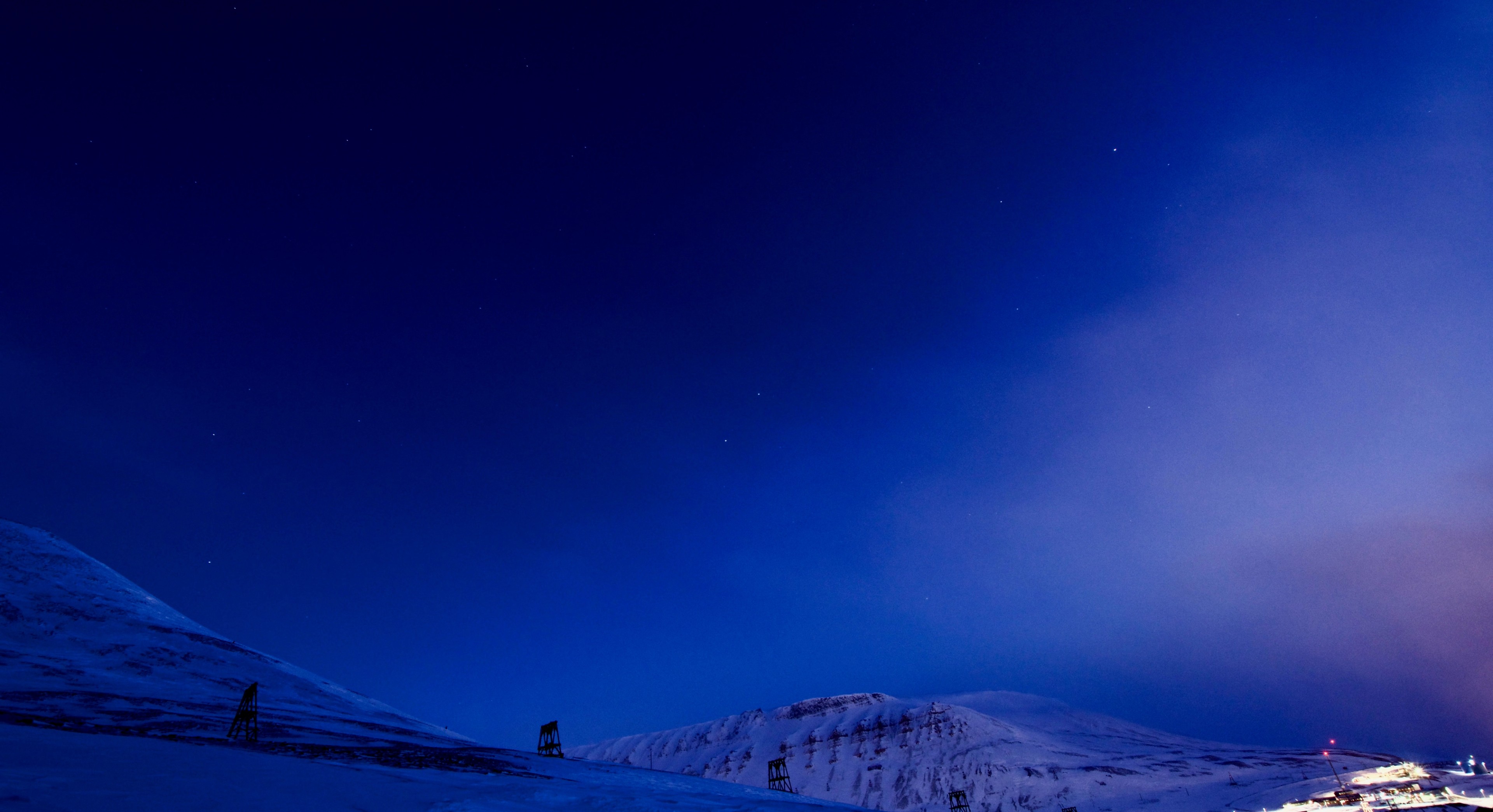 Blue twilight settles over a snowy mountain valley.
