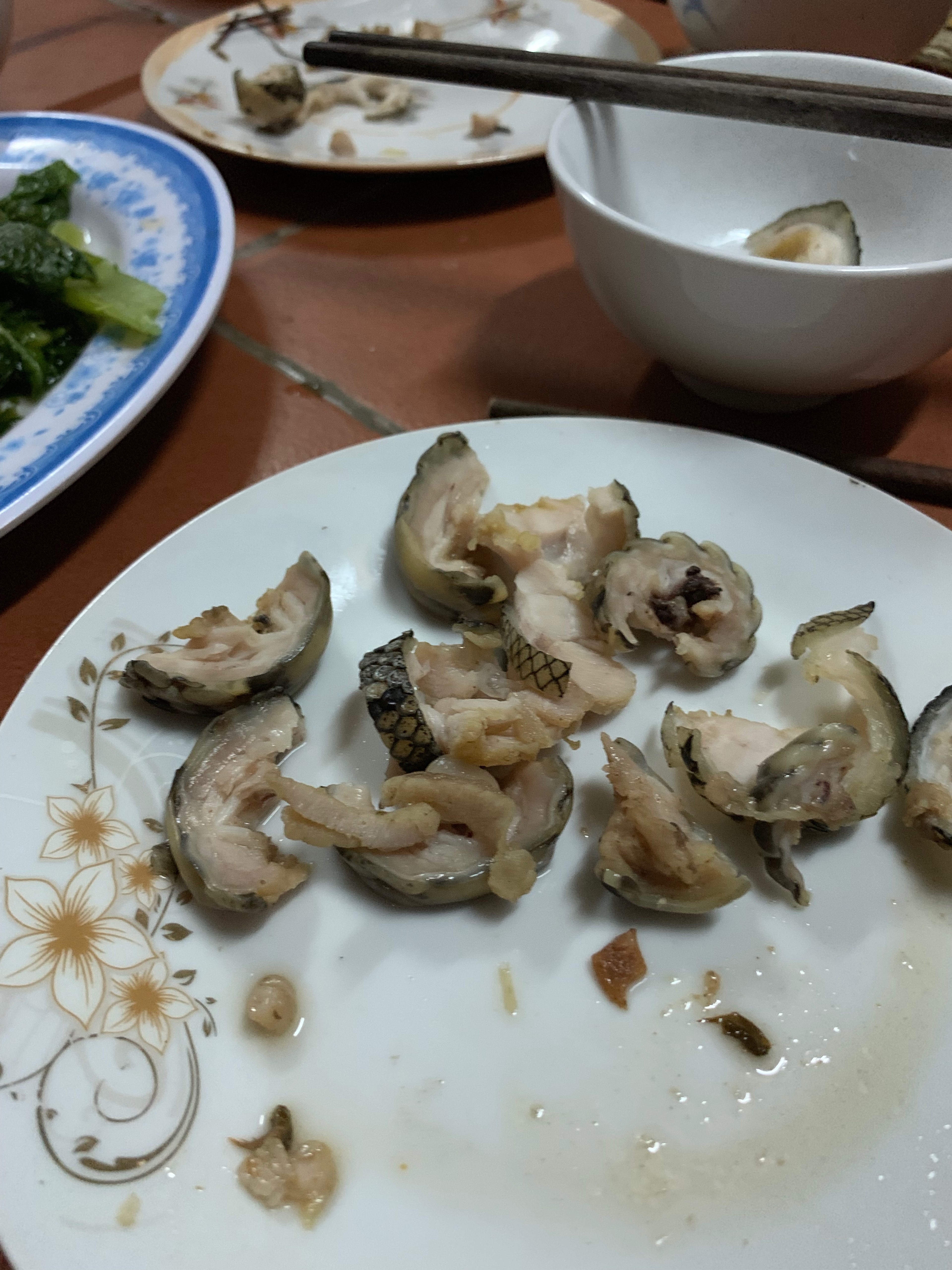 A plate of shellfish and seafood sits on a patterned table.