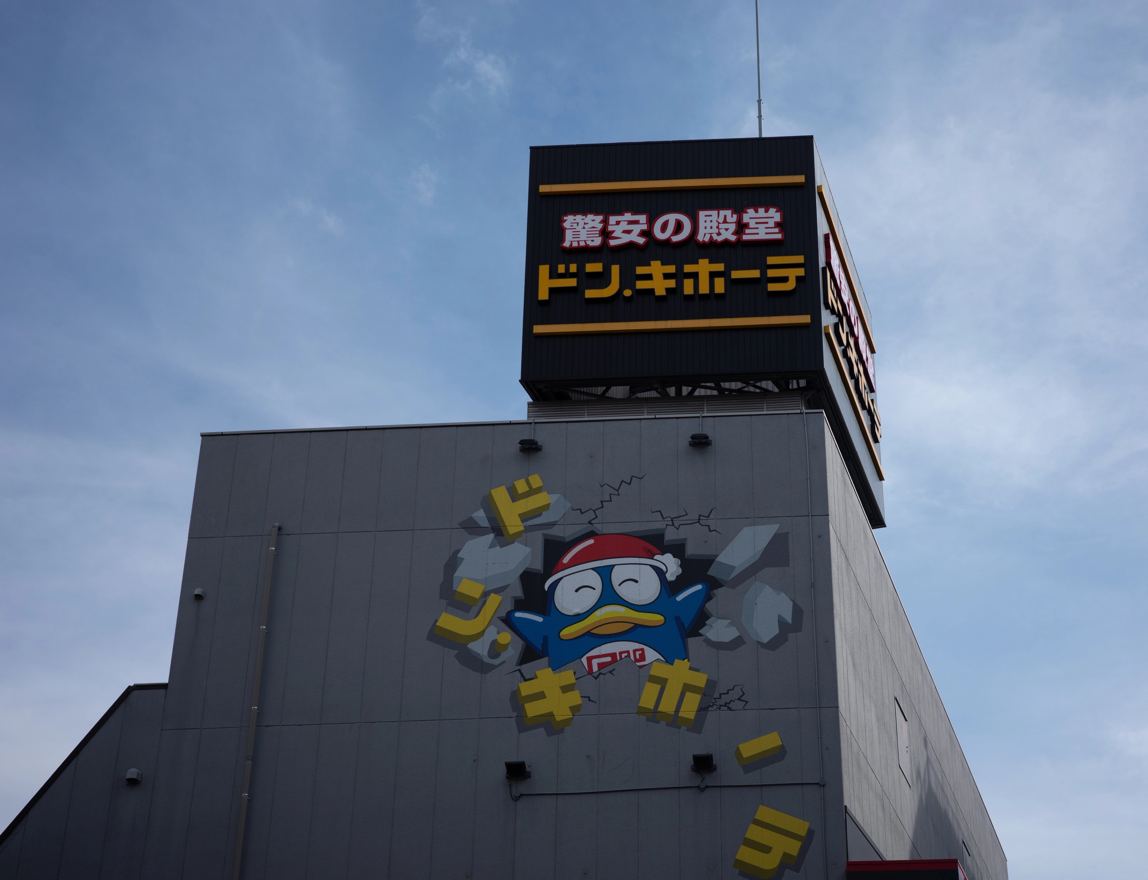 A cartoon figure decorates the facade of a tall building.