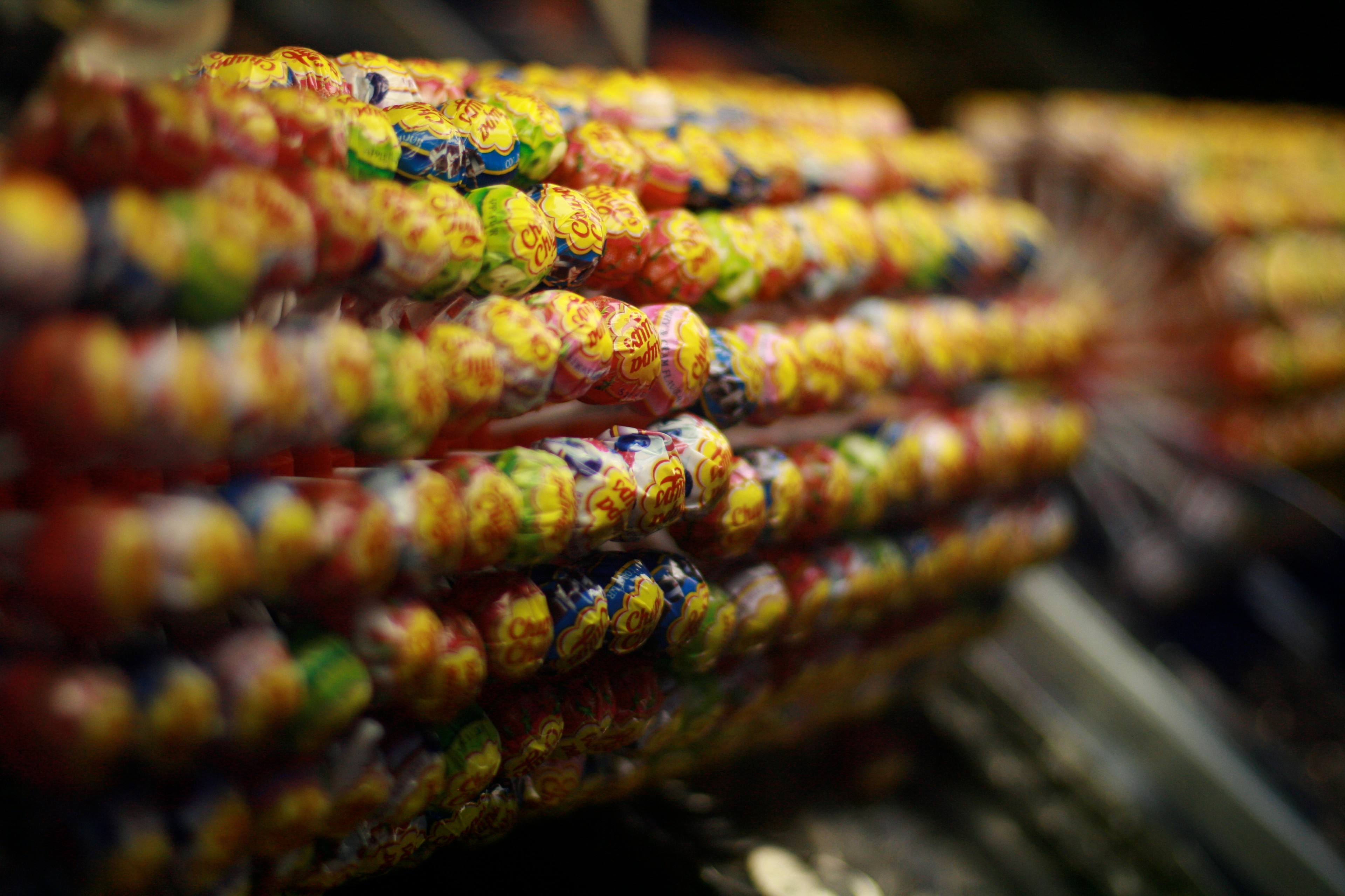 Rows of colorful packaged sweets fill a shop display.