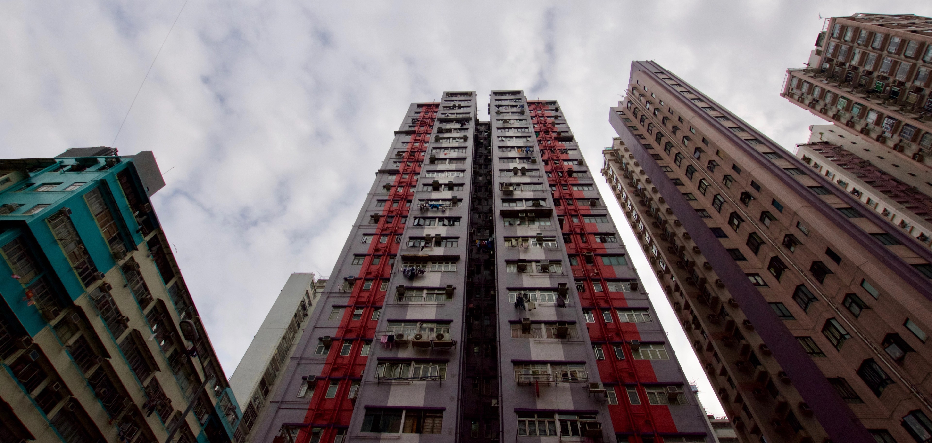 Tall residential towers rise above the street in a low-angle view.