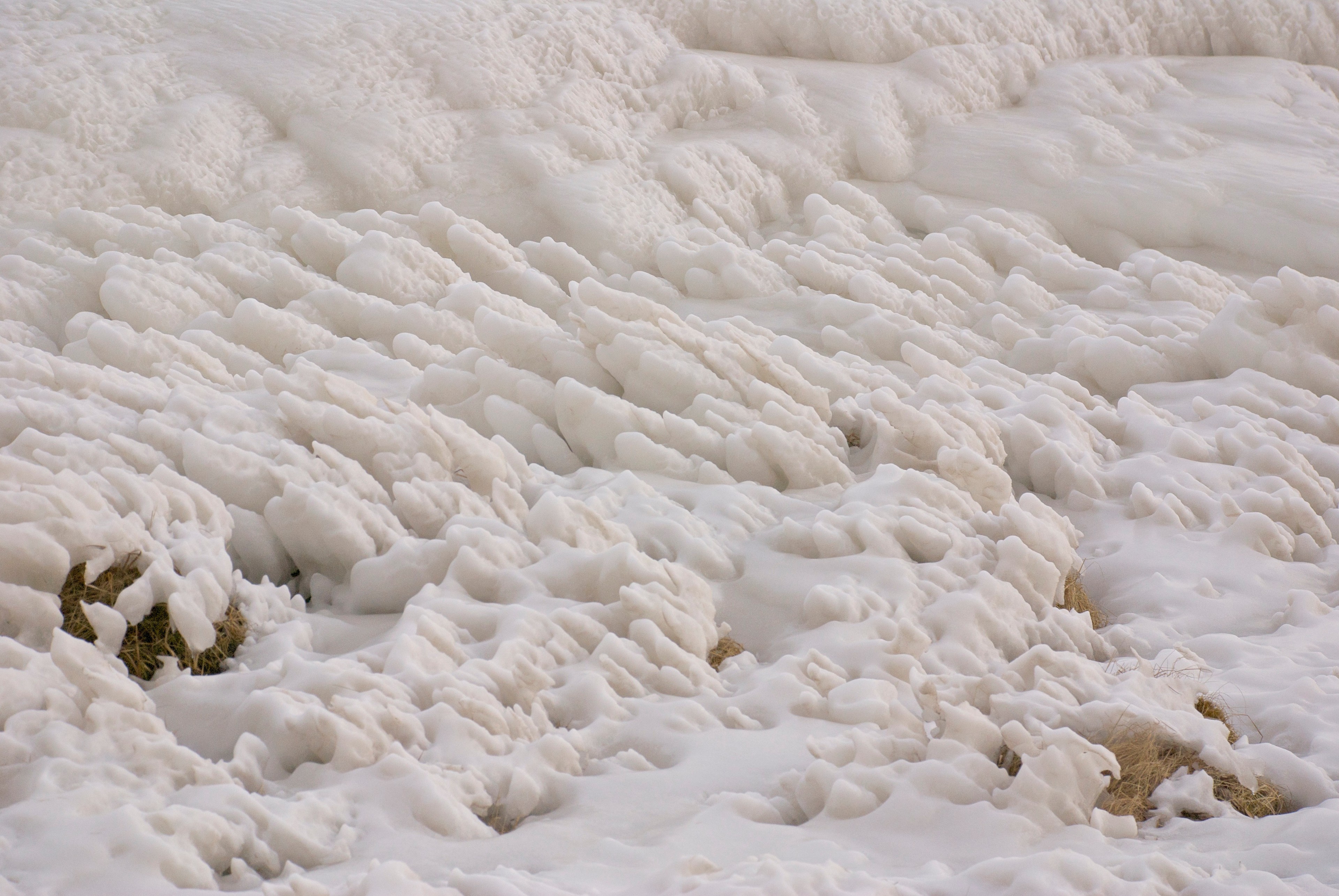 A close view of textured snow and ice with small crevices.