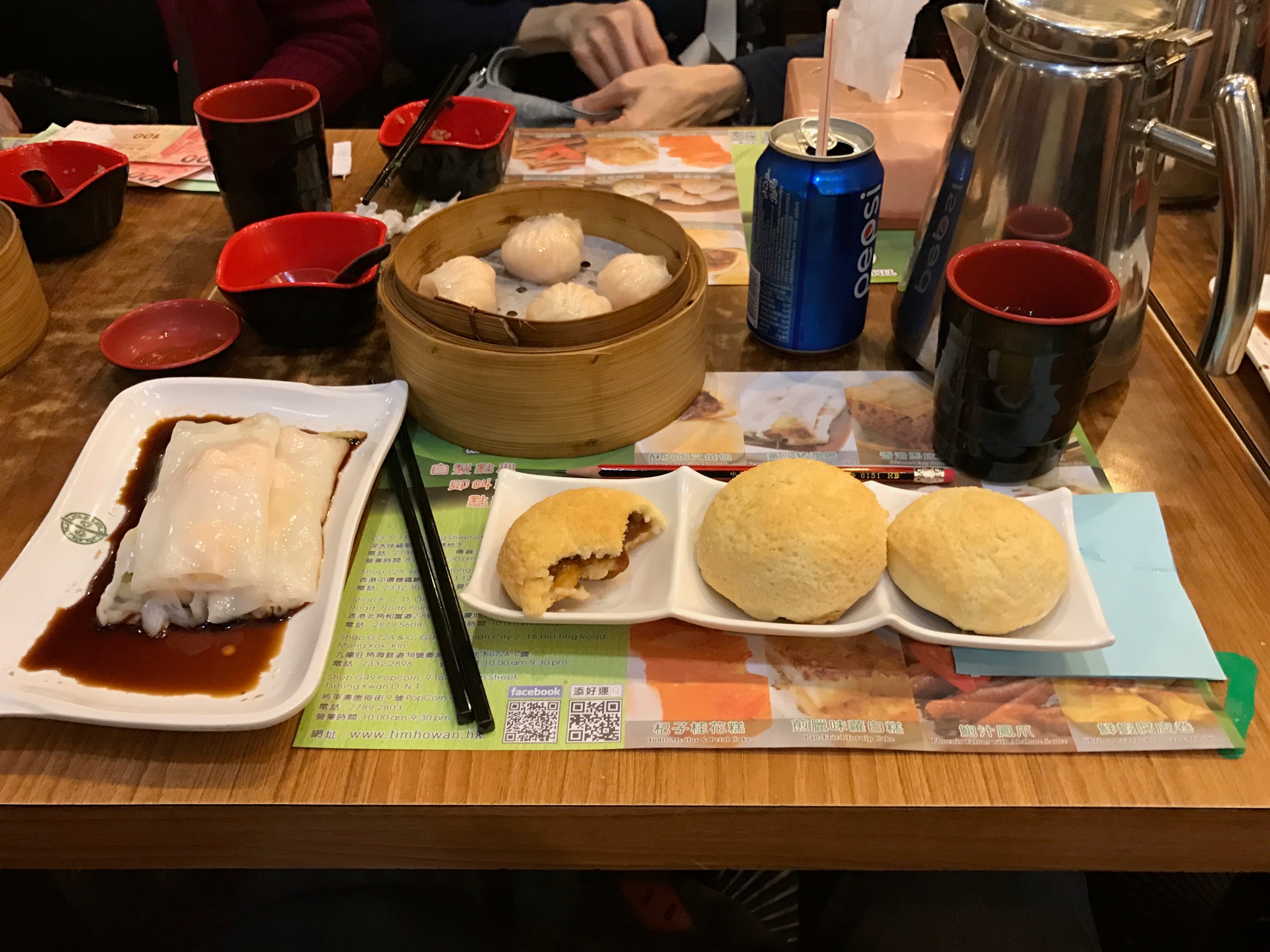 A set meal with buns, tea, and side dishes is arranged on a table.