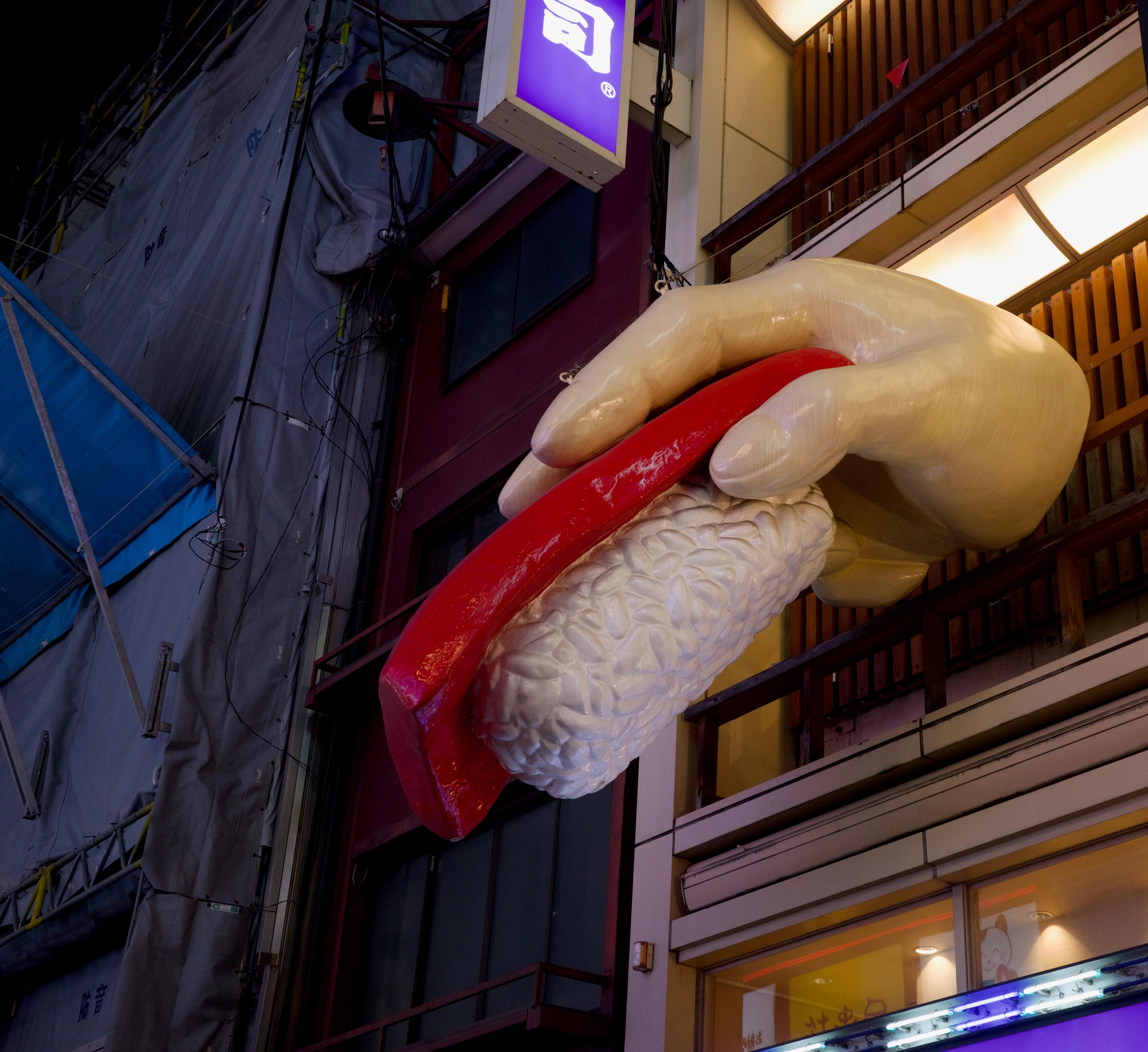 A giant crab claw sign hangs above a brightly lit storefront.