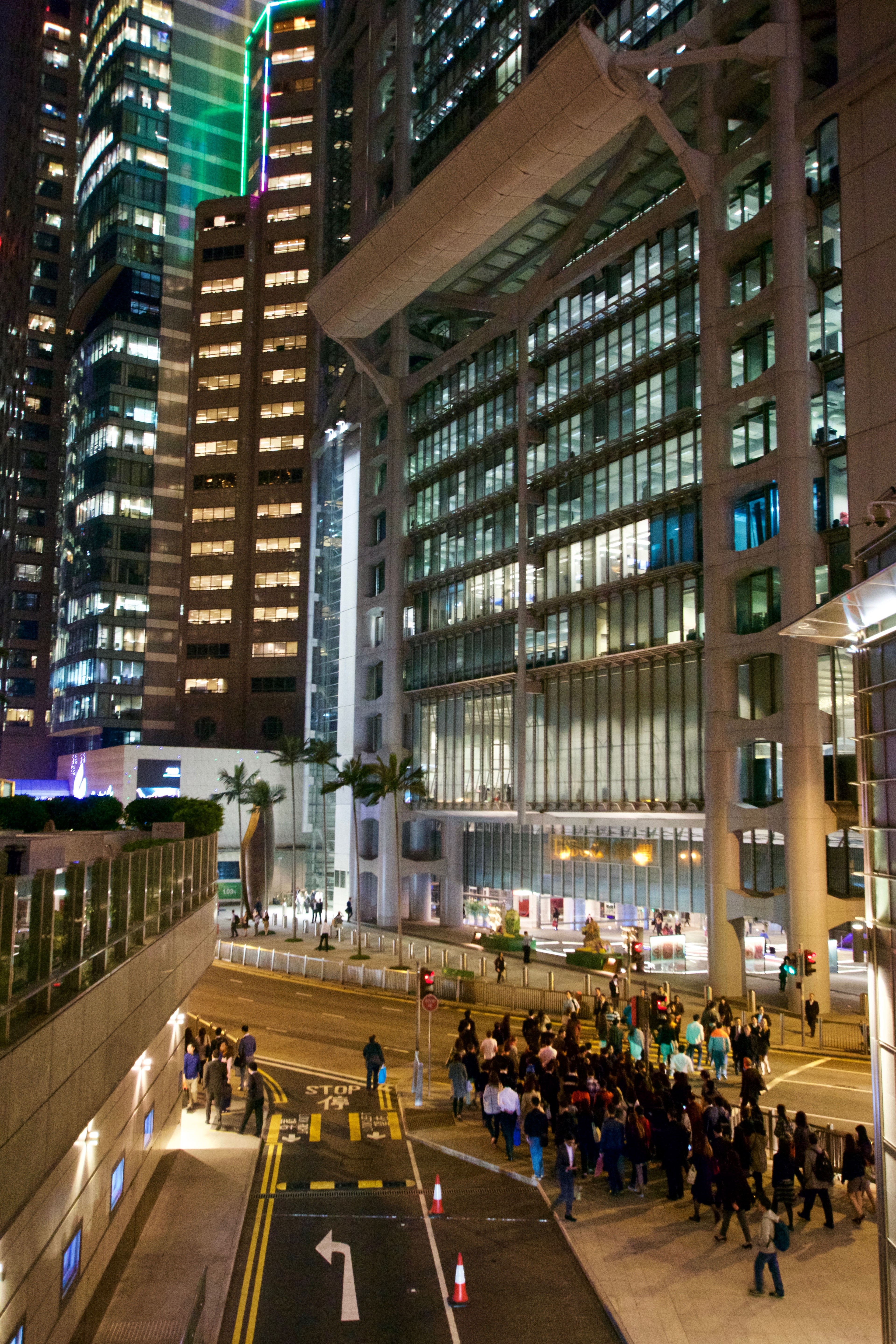 A tall office building glows with rows of lights after dark.