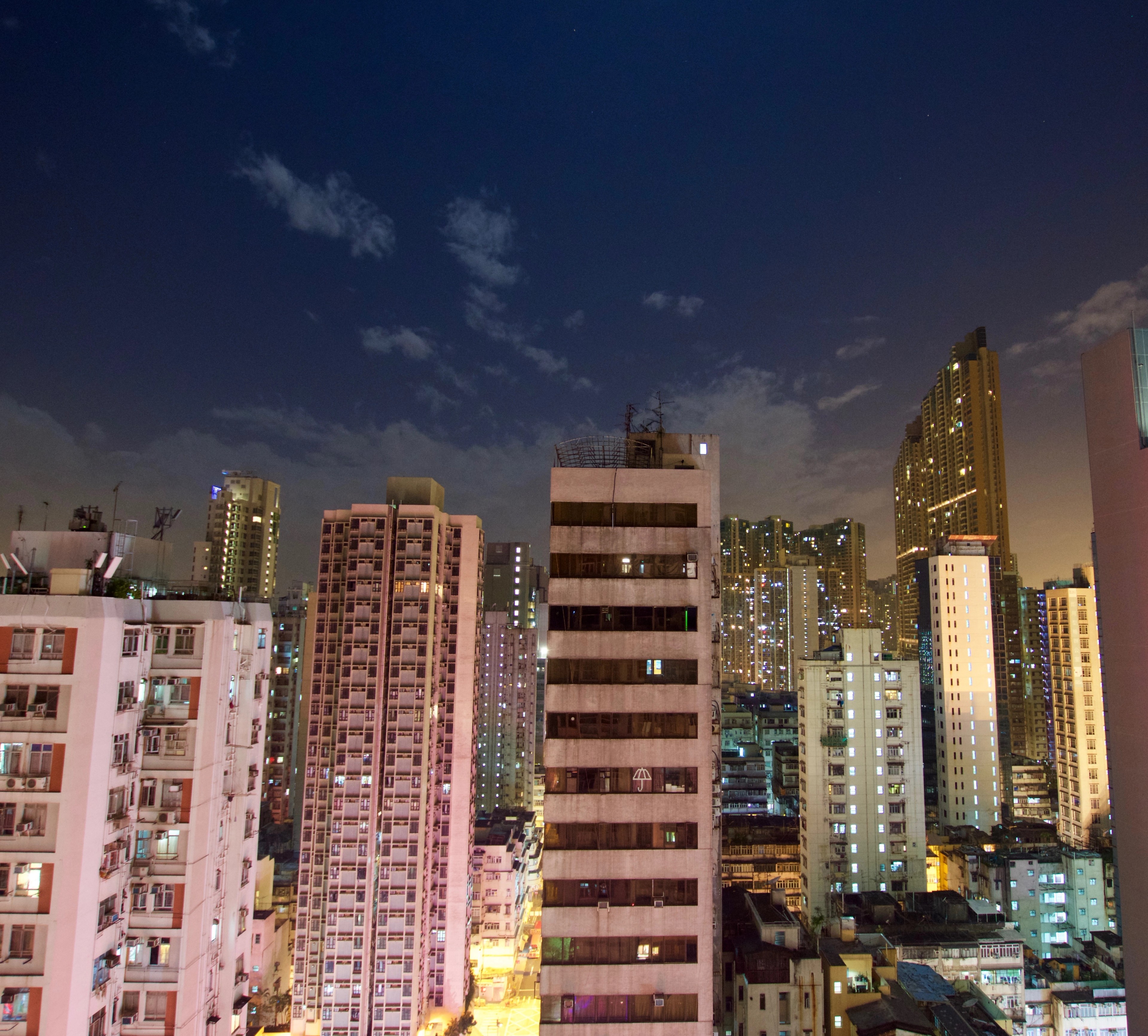 Tall apartment blocks glow against the evening sky.