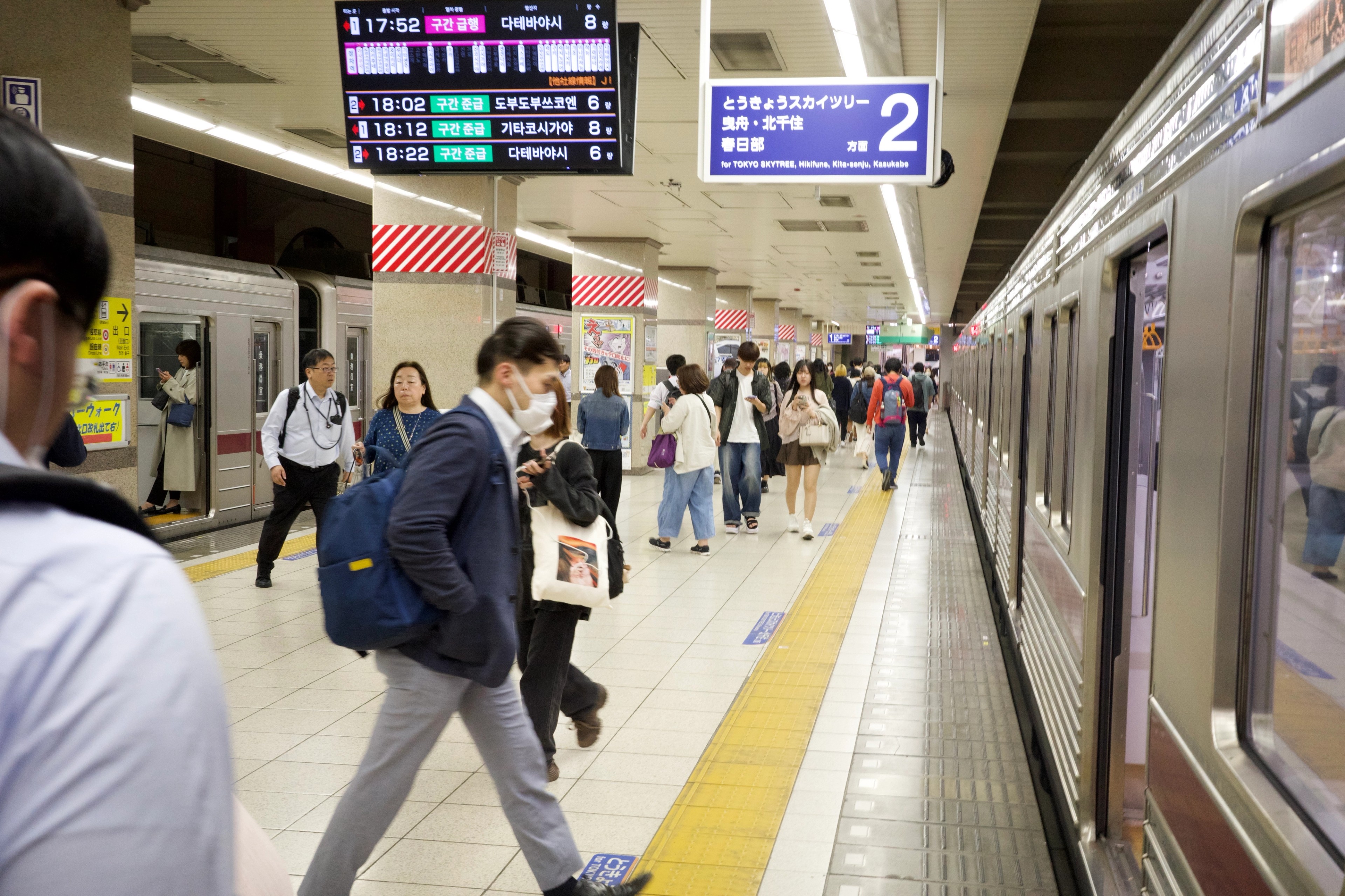 Commuters wait on a busy subway platform.