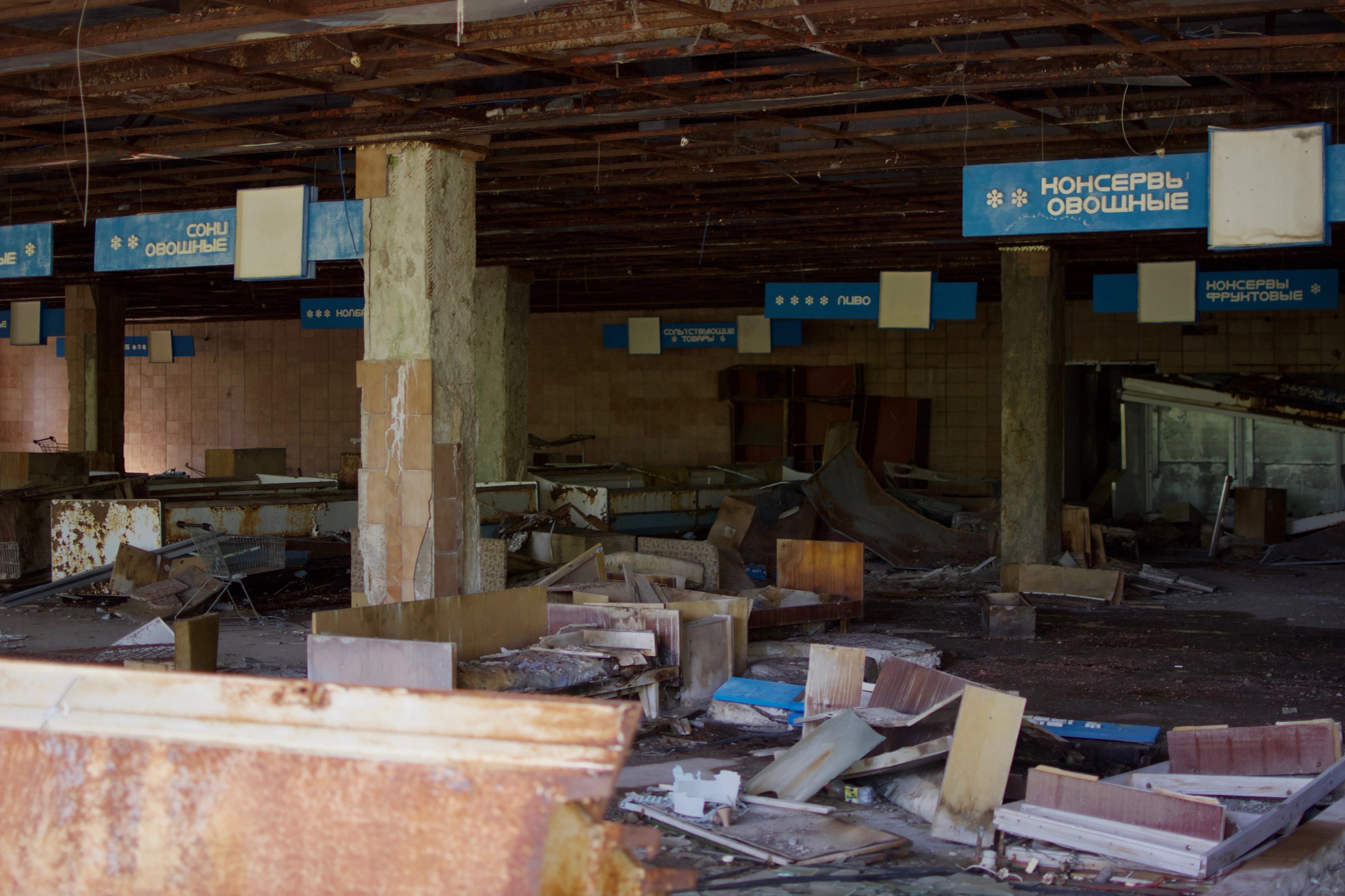 Old service counters and seating in an abandoned hall.