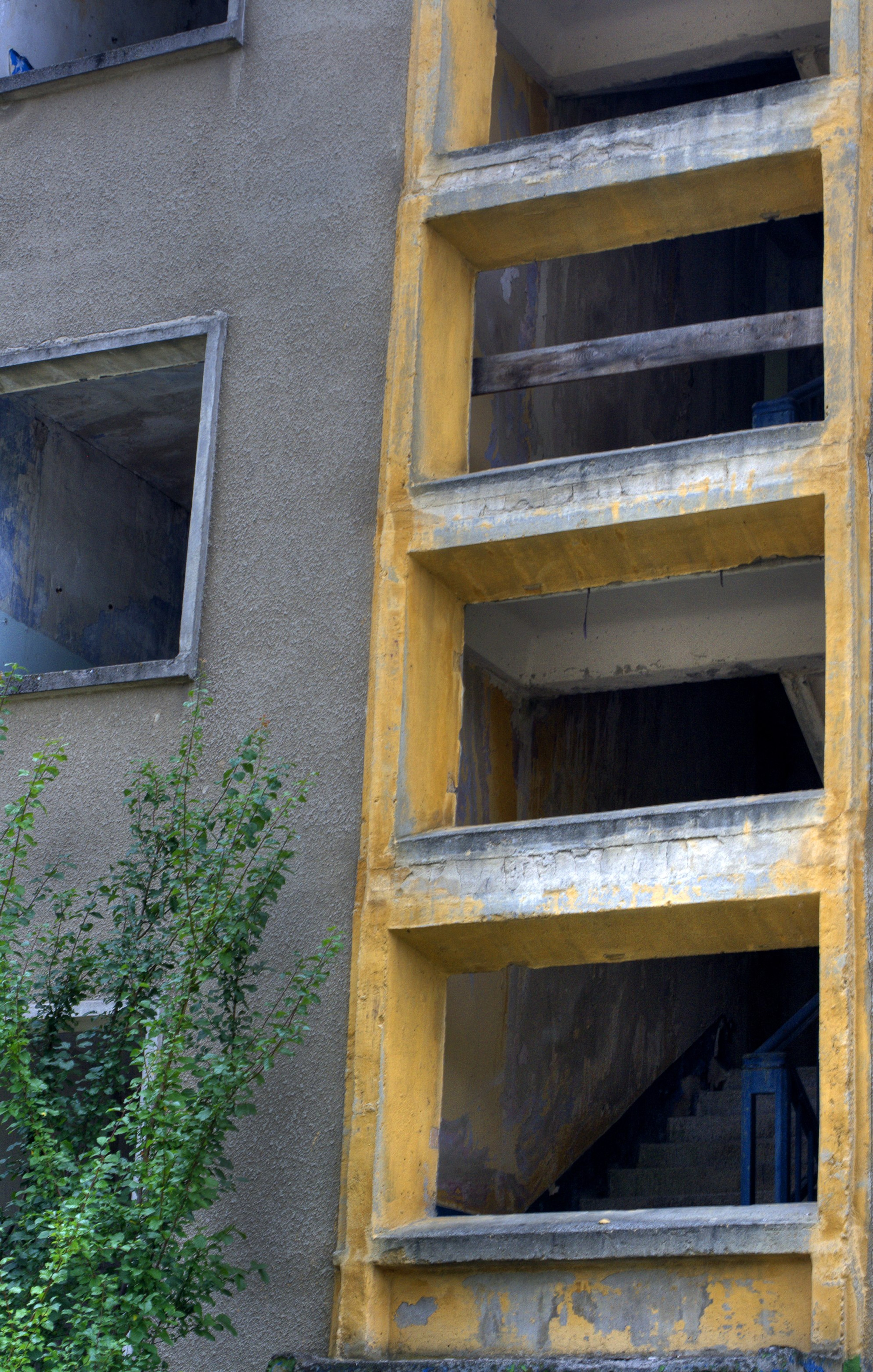 A narrow yellow exterior stairwell runs up the side of a building.