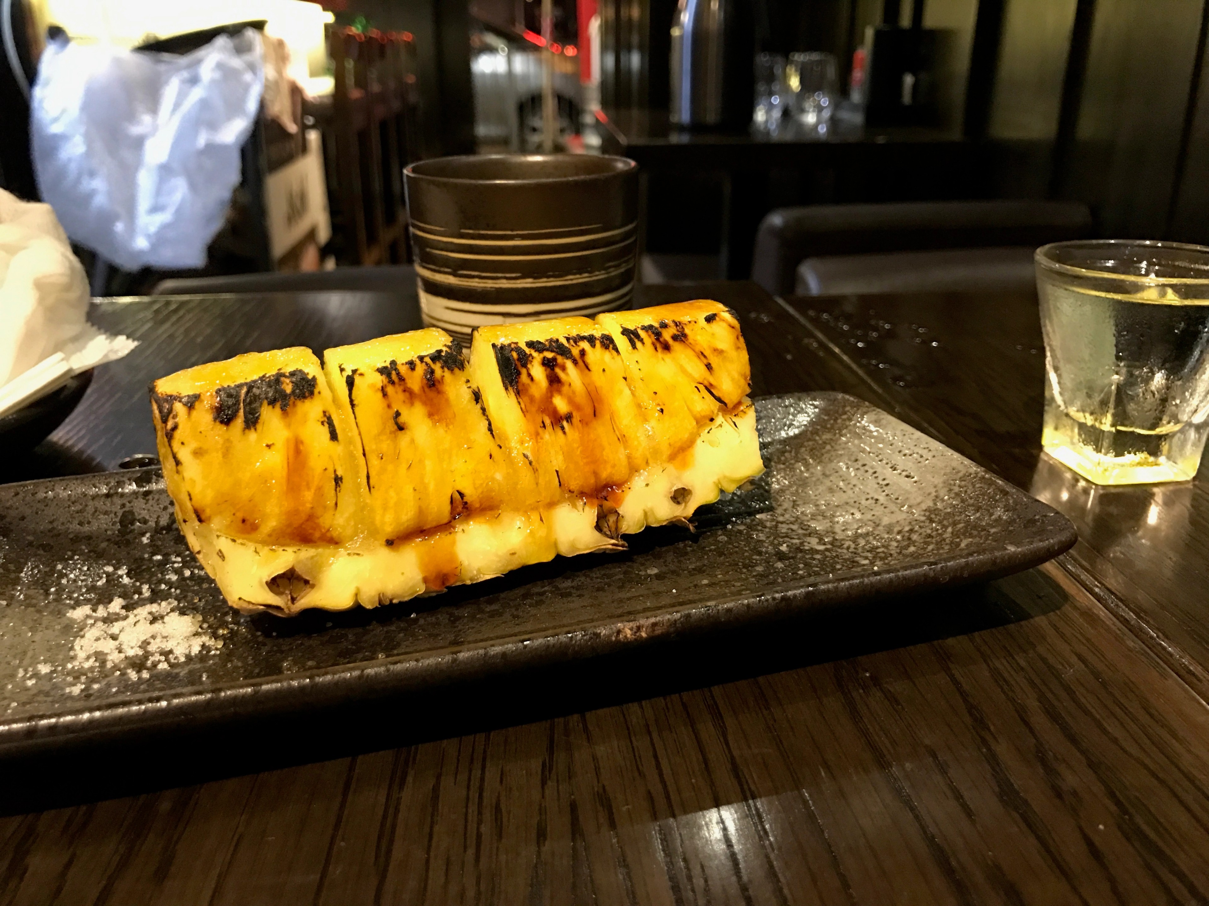 Golden rectangular dessert pieces sit on a dark serving plate.