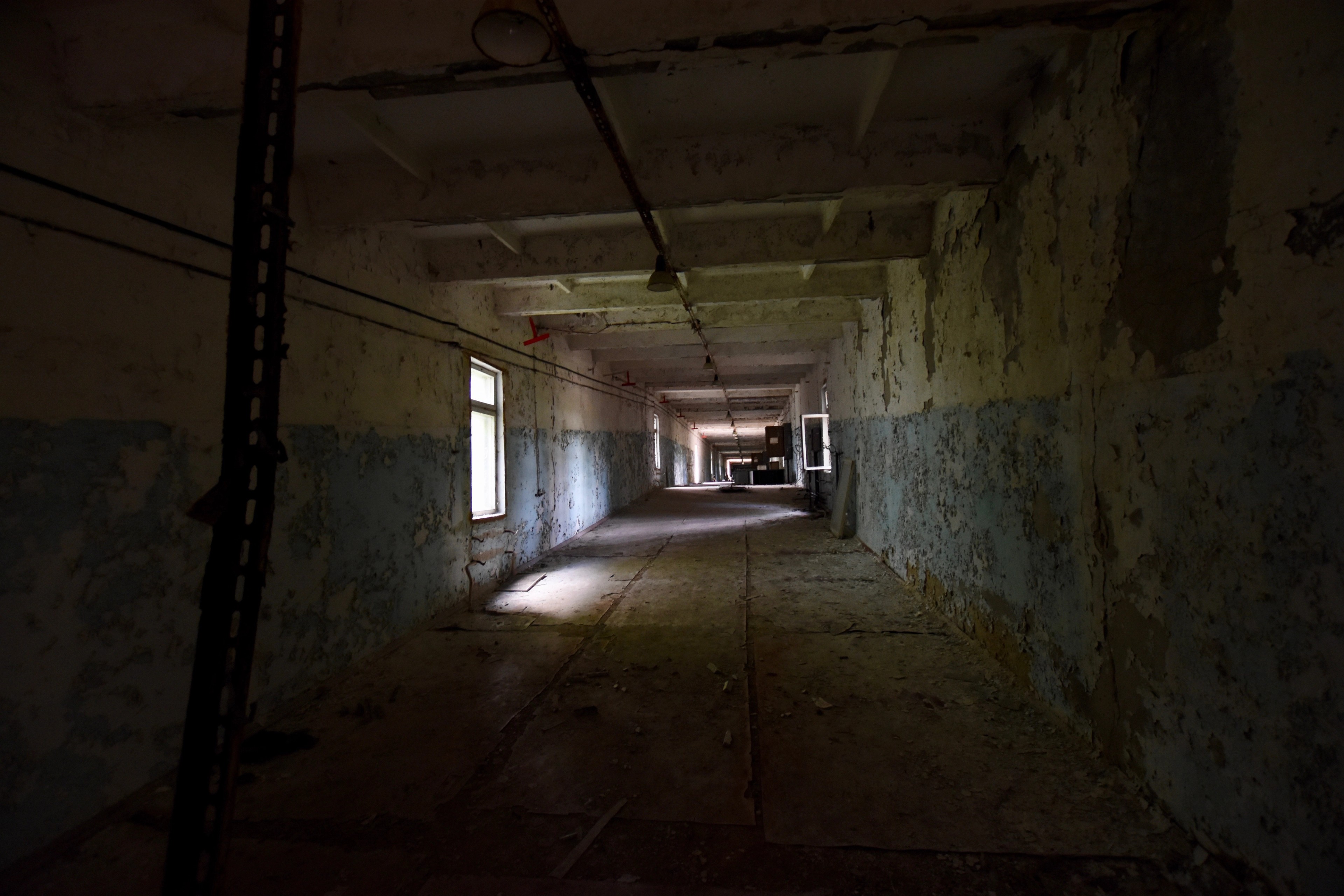 A long empty corridor inside an abandoned building.
