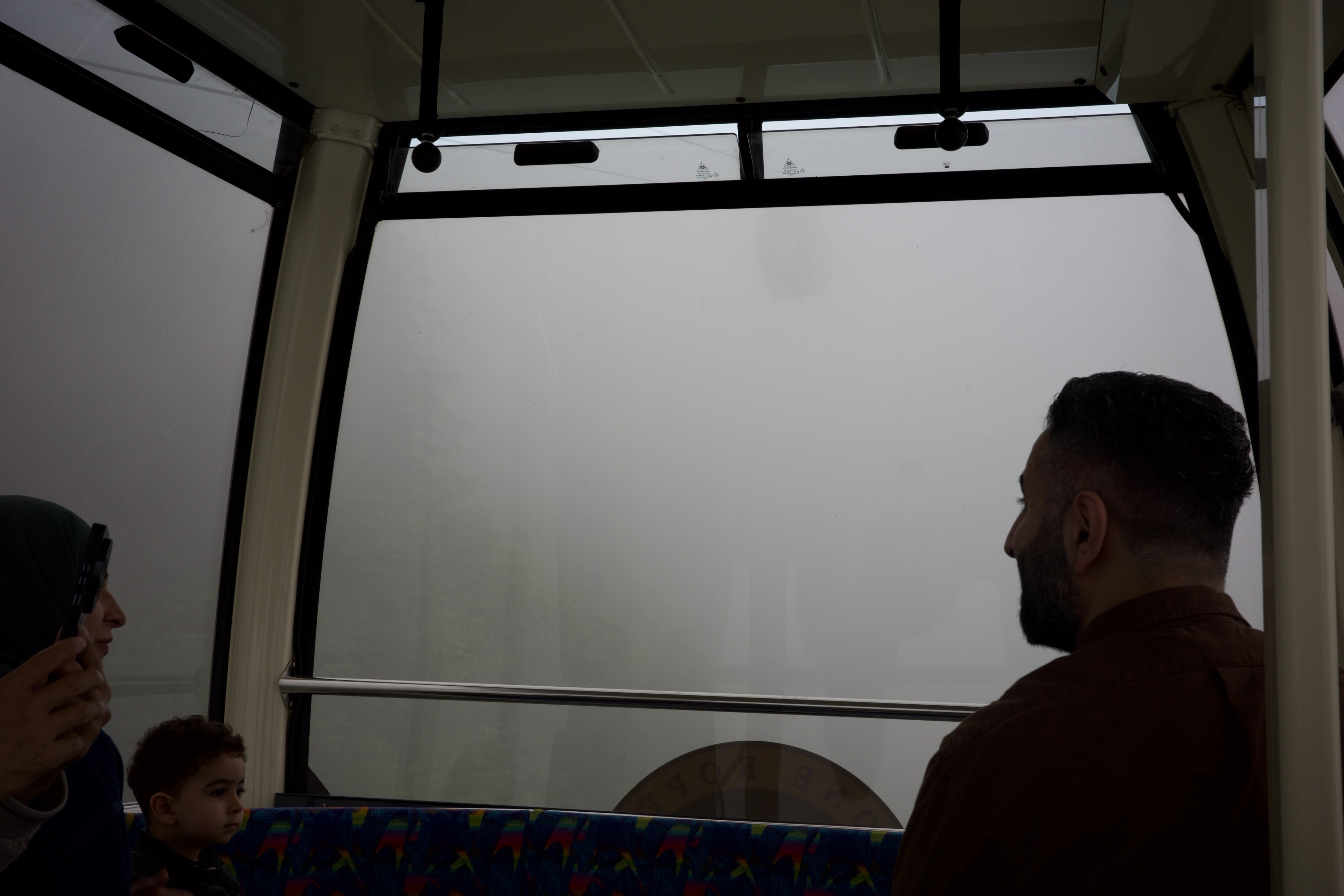 Passengers look out from inside a cable car.