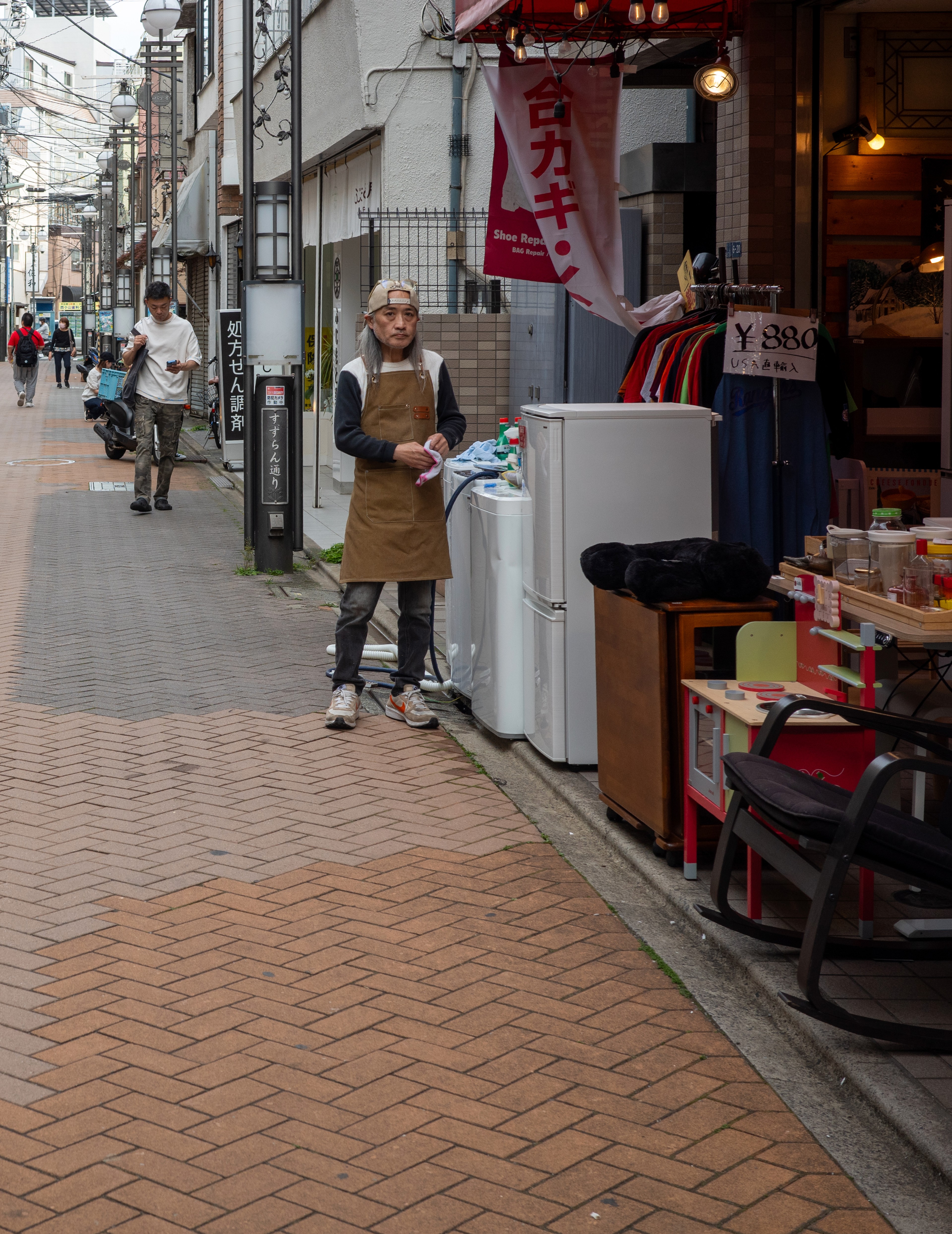 A shop opens onto a narrow neighborhood sidewalk.