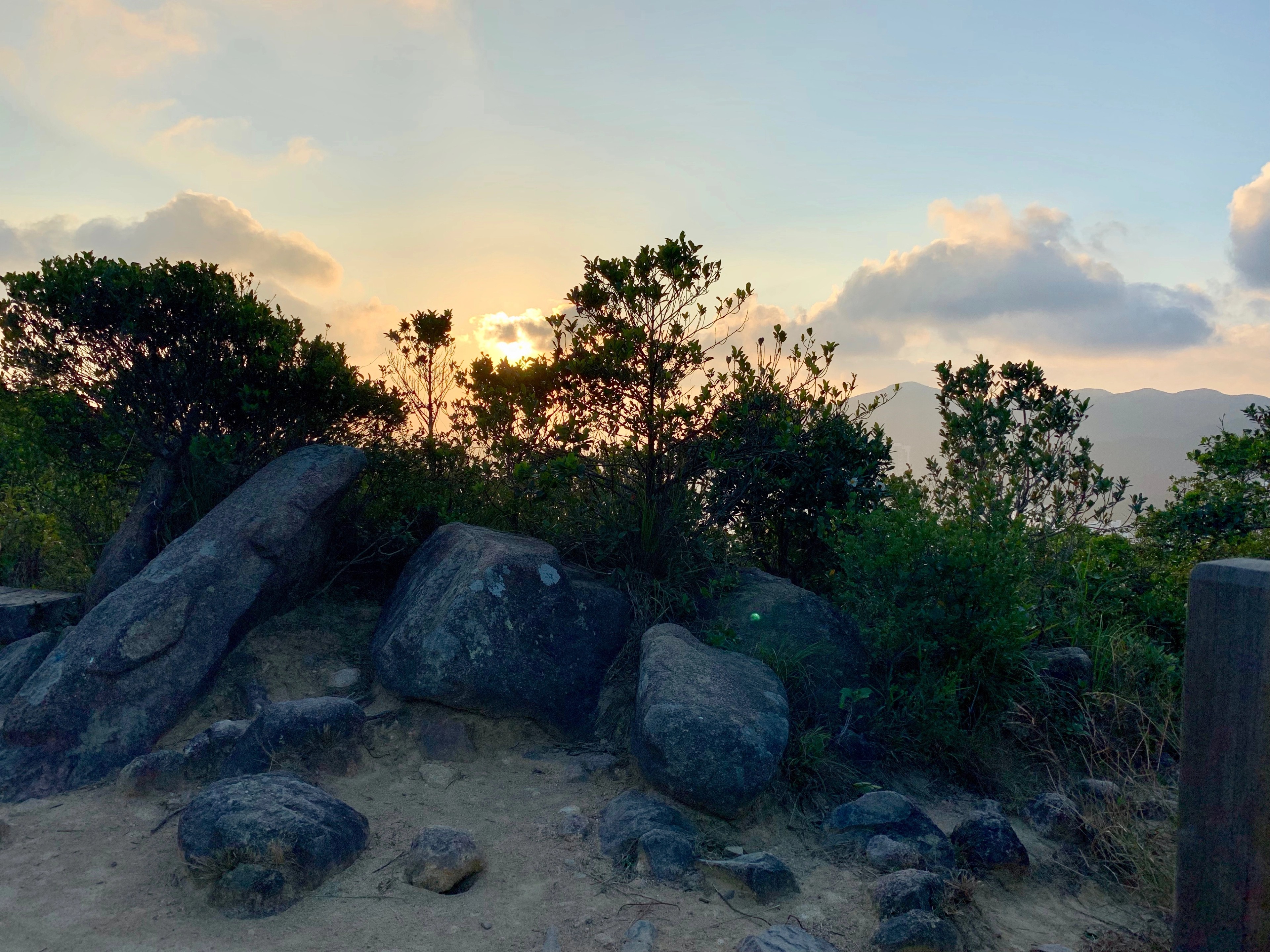 A rocky hiking path passing a large boulder.