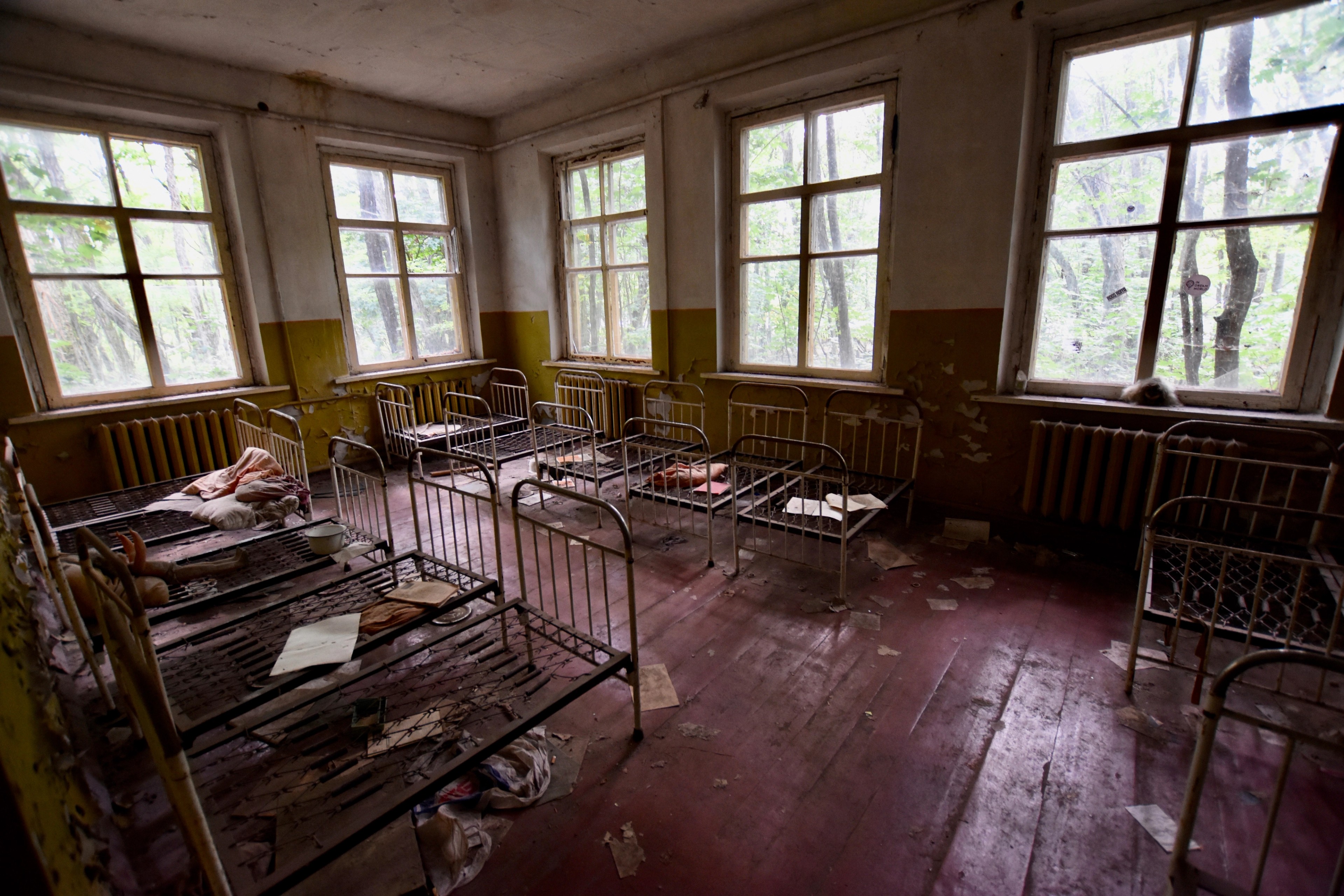 Rows of metal desks stand in an empty classroom.