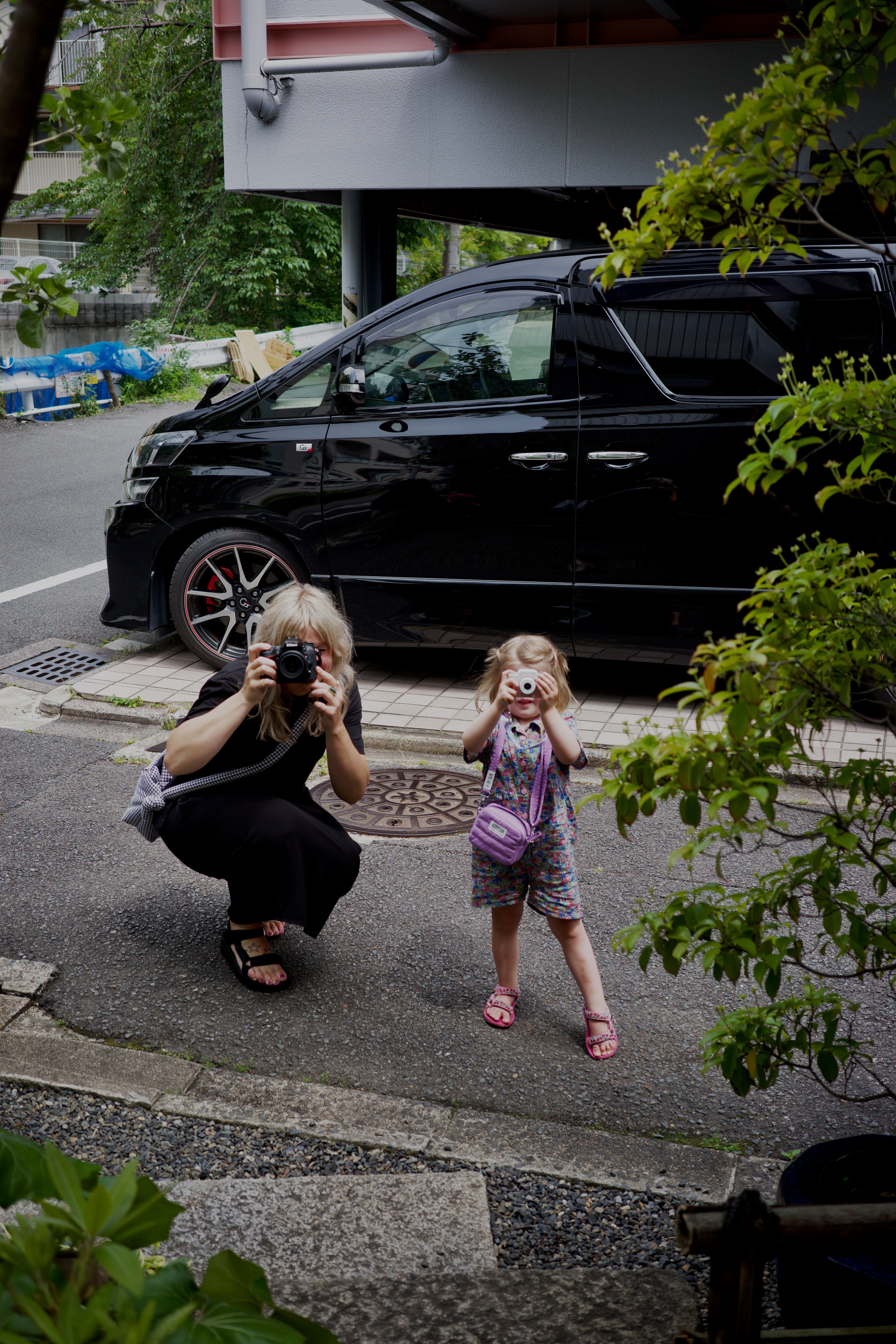 An adult and child walk beside a quiet residential road.