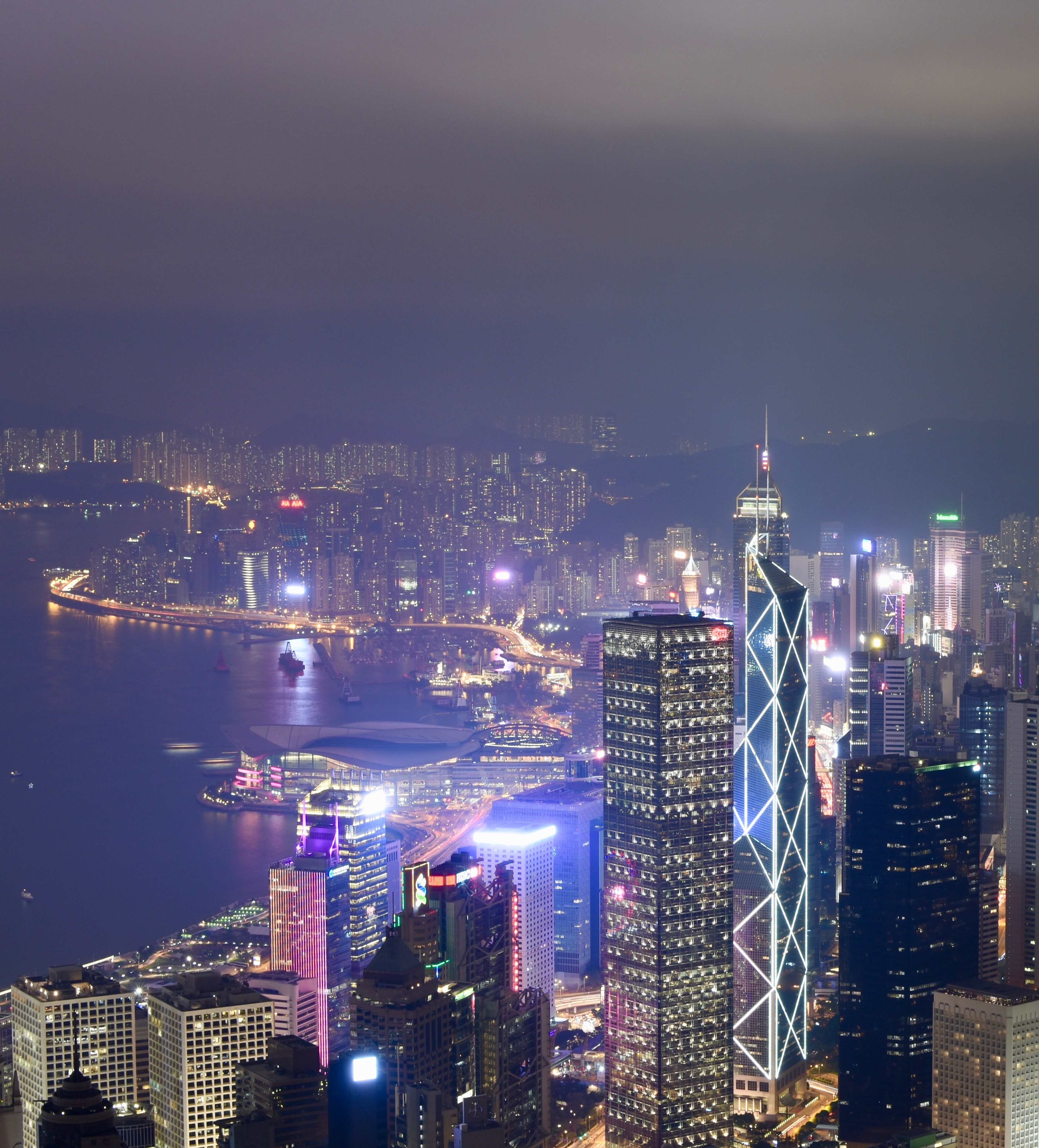 Tall illuminated Hong Kong buildings at night.